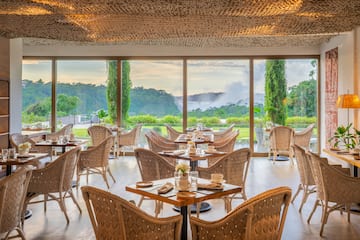 a room with tables and chairs and a view of the mountains