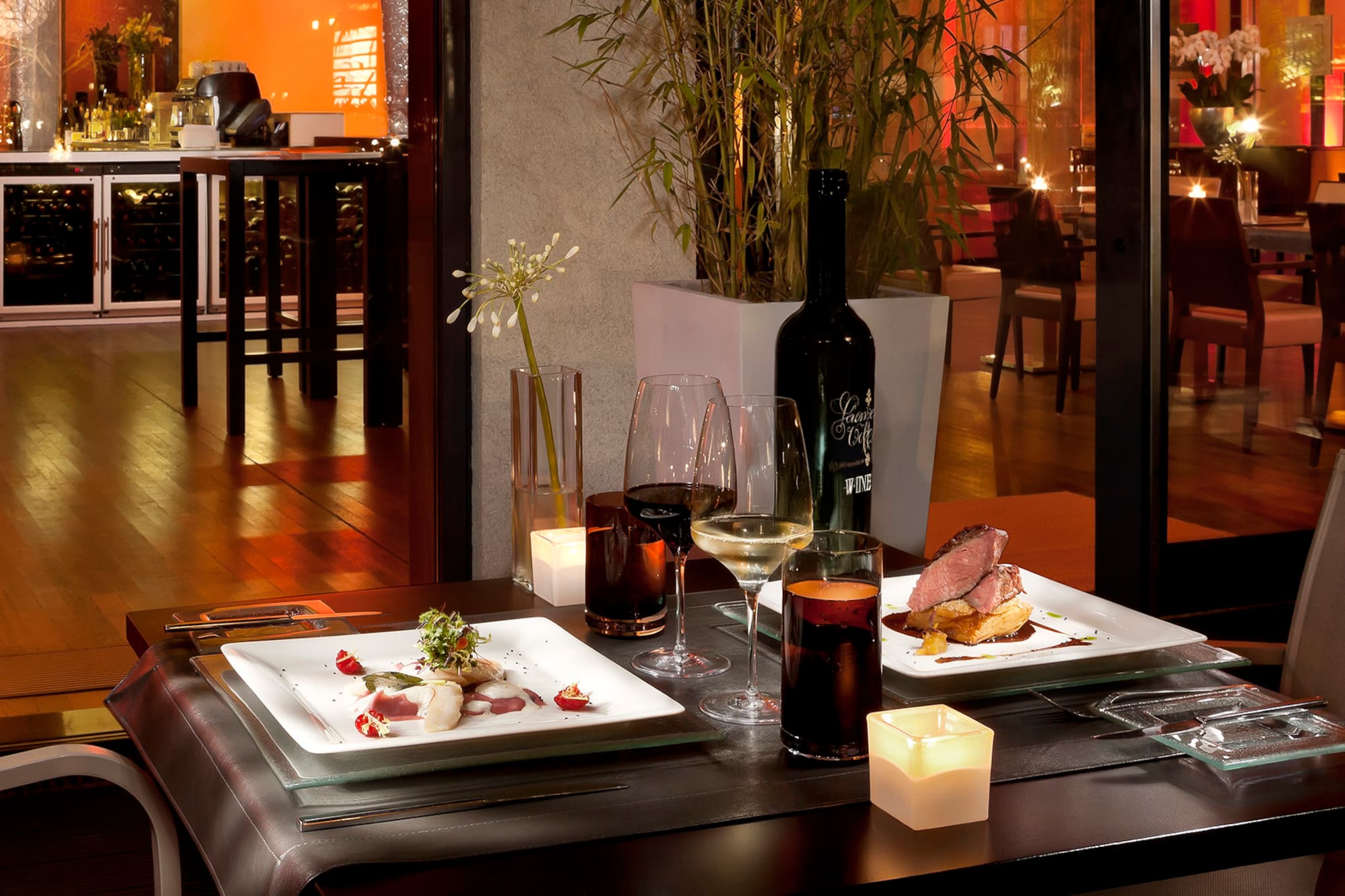 a table with plates of food and wine glasses