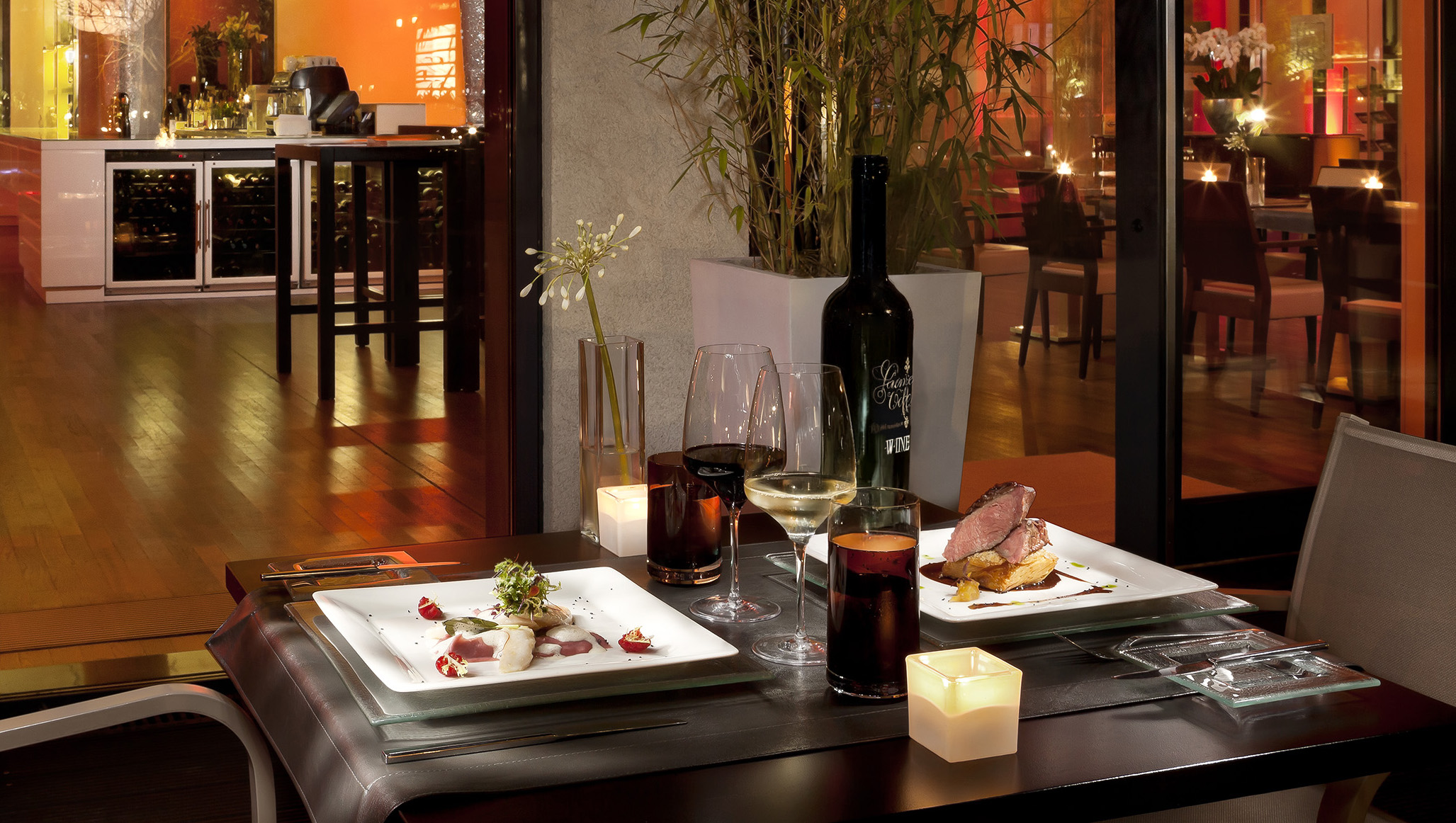 a table with plates of food and wine glasses