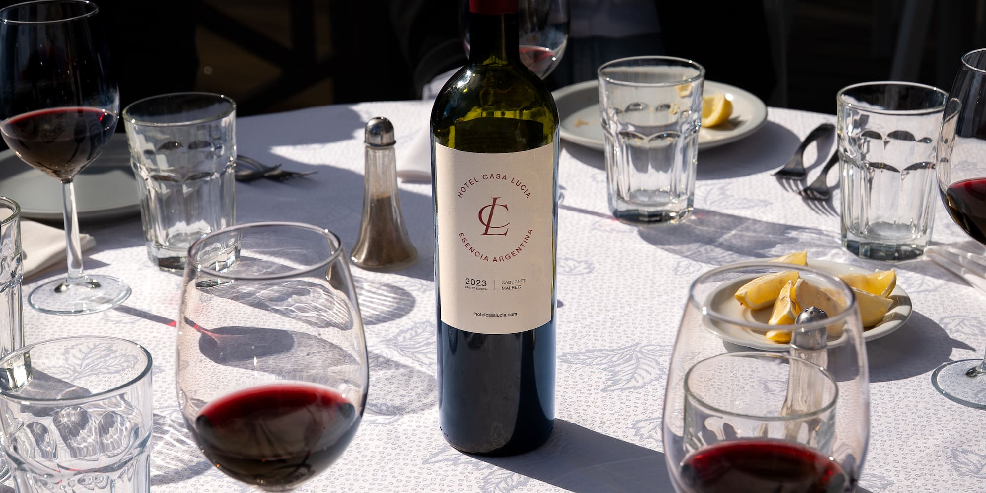 a wine bottle on a table with glasses and plates