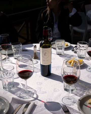 a wine bottle on a table with glasses and plates