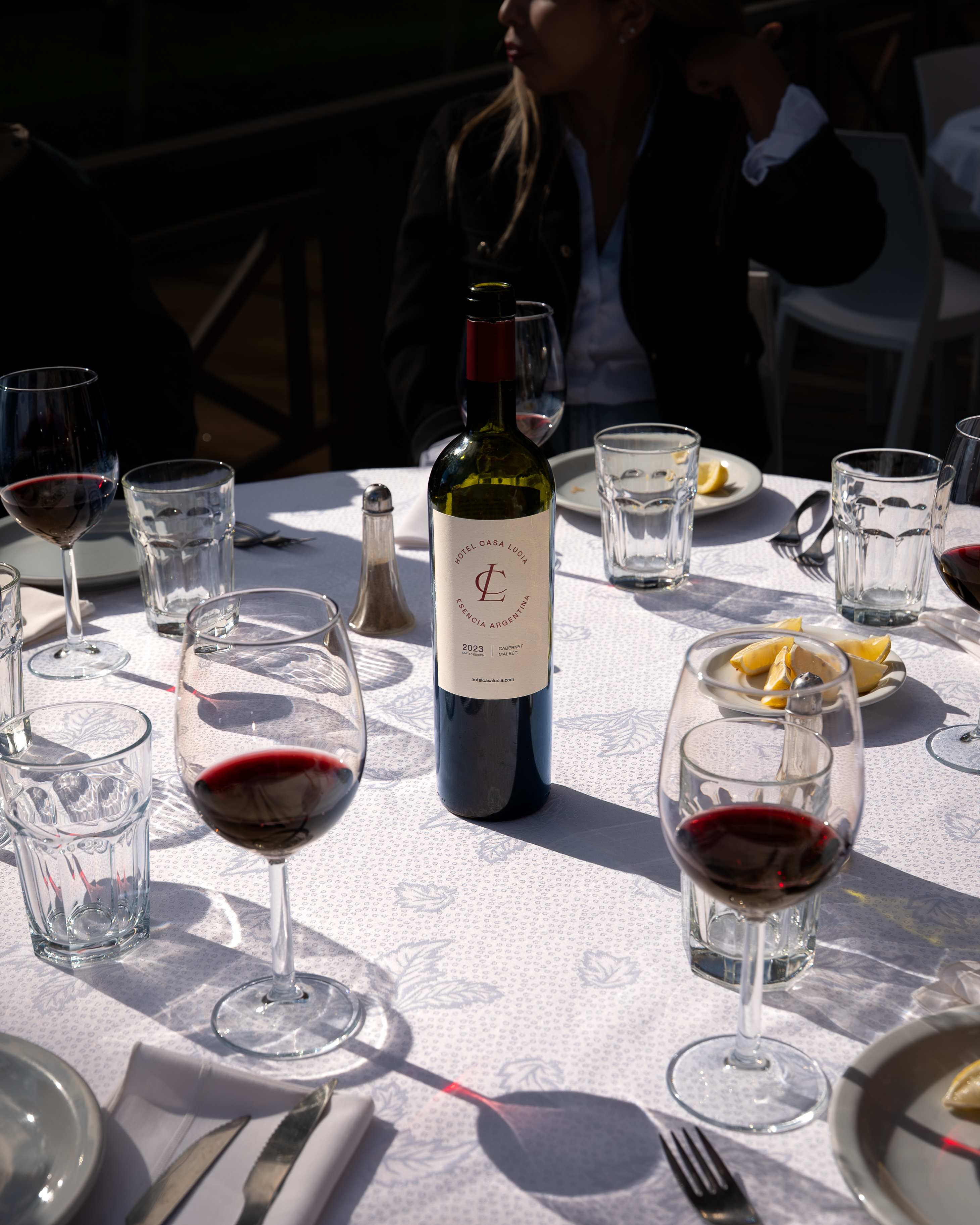 a wine bottle on a table with glasses and plates