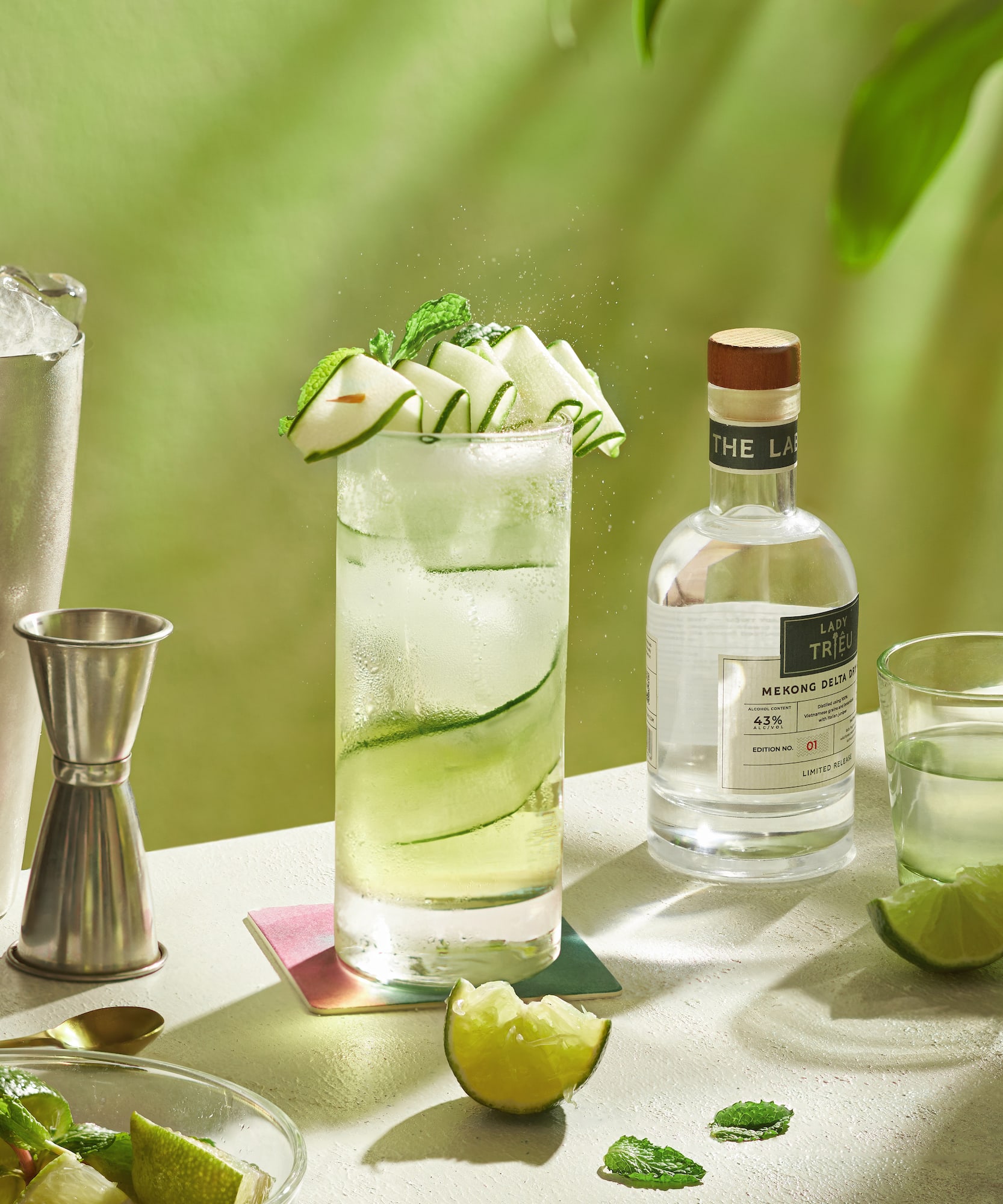 a glass of liquid with slices of apple on top and a bottle of alcohol