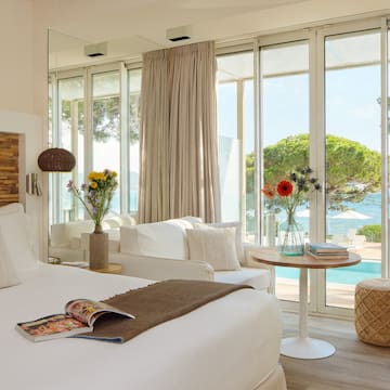 a room with a bed and a table and chairs