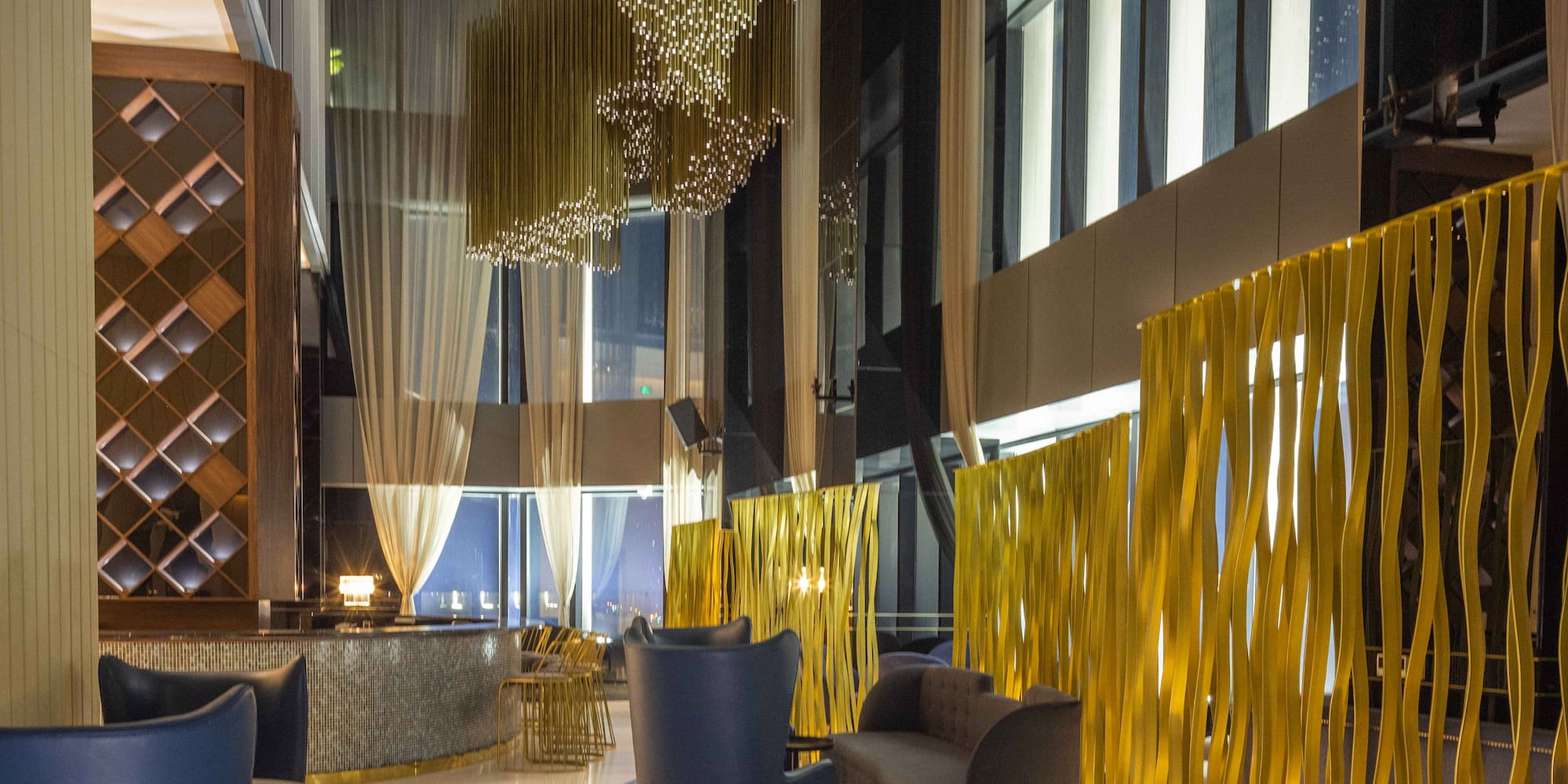 a room with a gold curtain wall and chairs