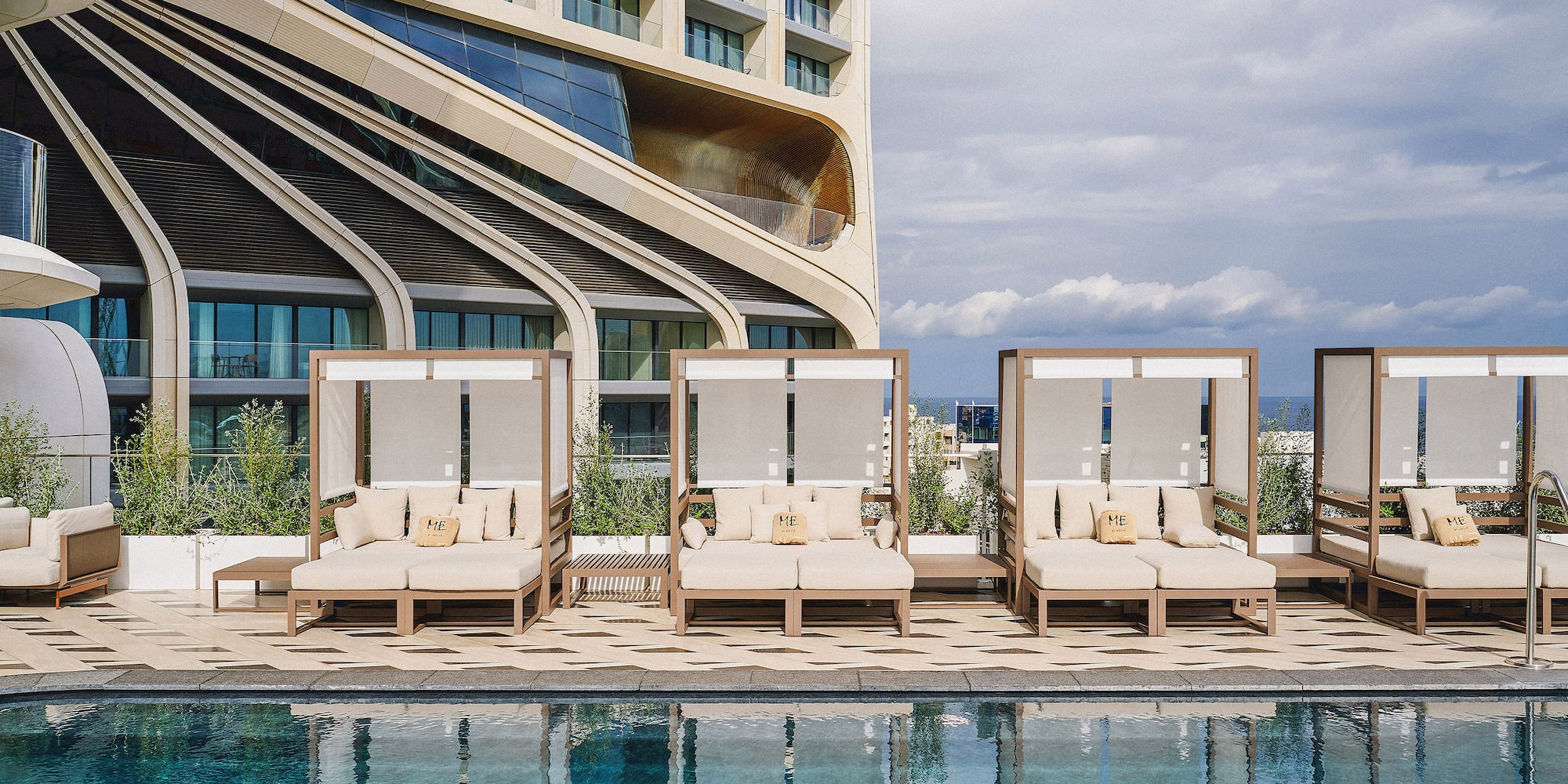 a pool with lounge chairs and a building in the background