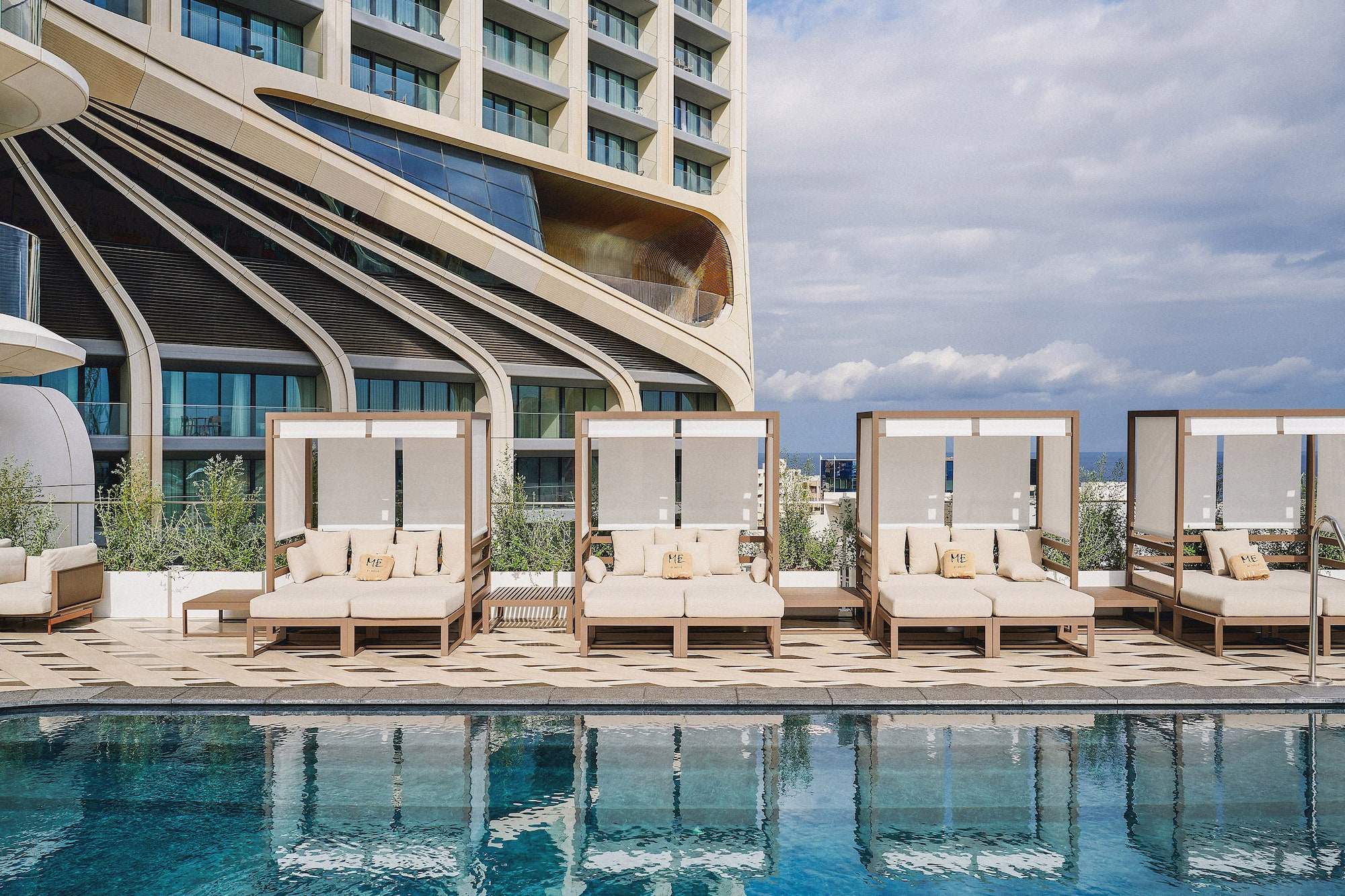 Luxury resort pool with modern cabanas and a contemporary architectural hotel.