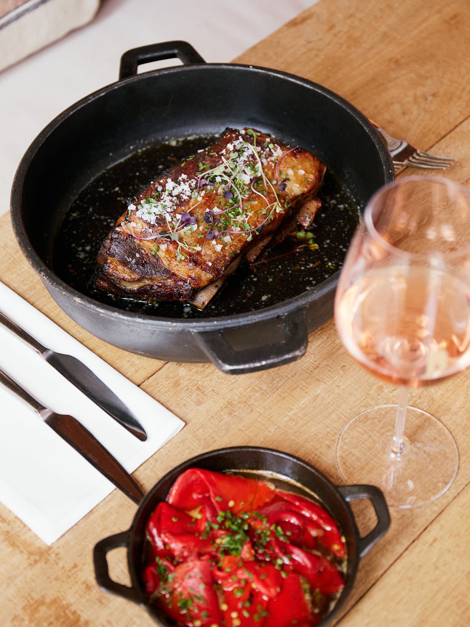 a pan of food and a glass of wine