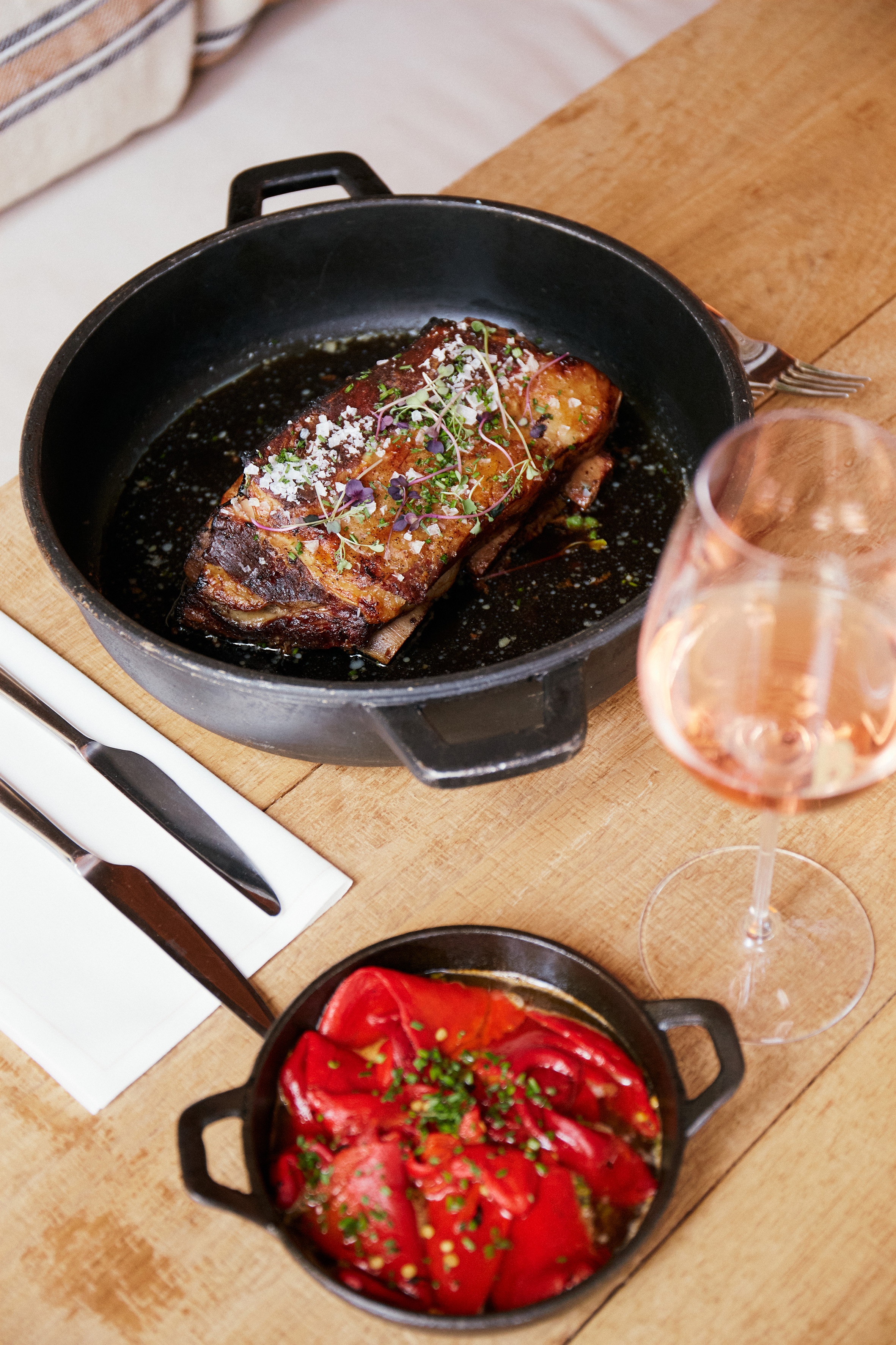 Gourmet braised ribs, roasted red peppers in cast iron, and rosé wine.