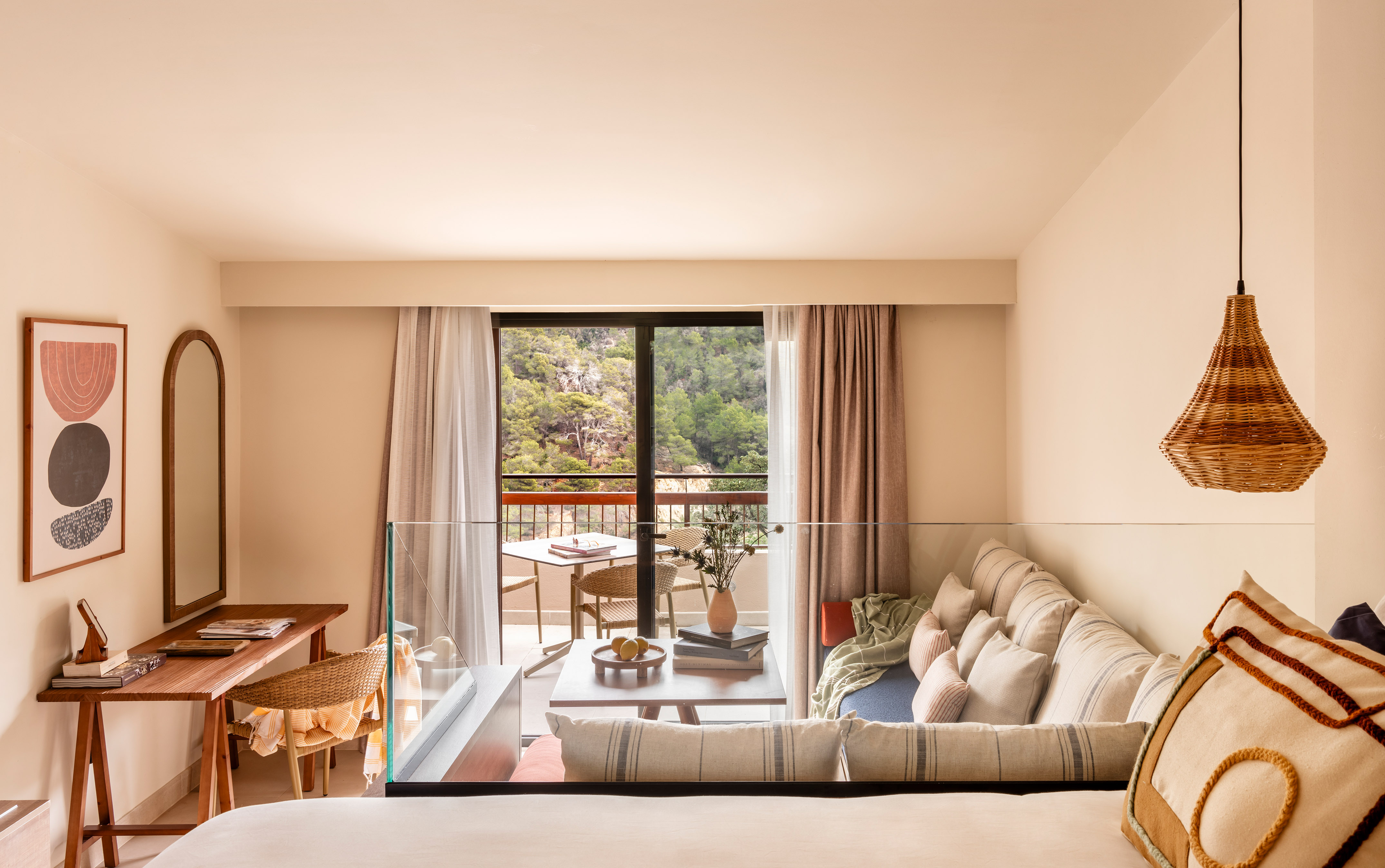 Modern hotel room with balcony, mountain view, and natural cozy decor.