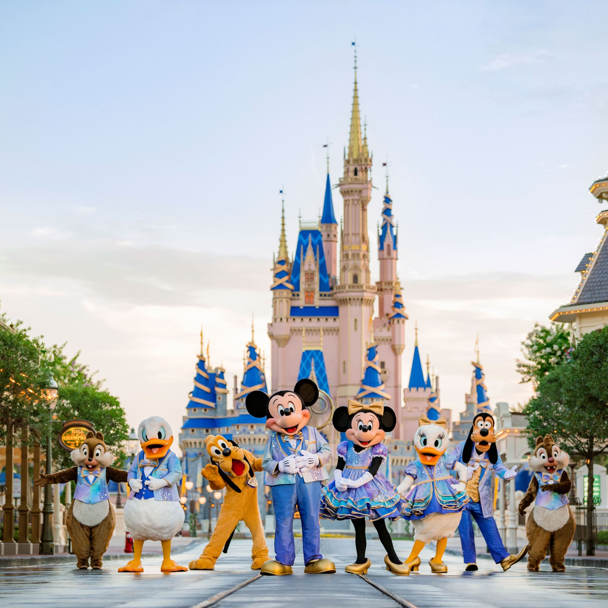 a group of people in clothing in front of a castle