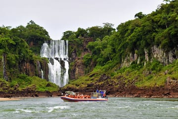 a boat with people in it in front of a waterfall