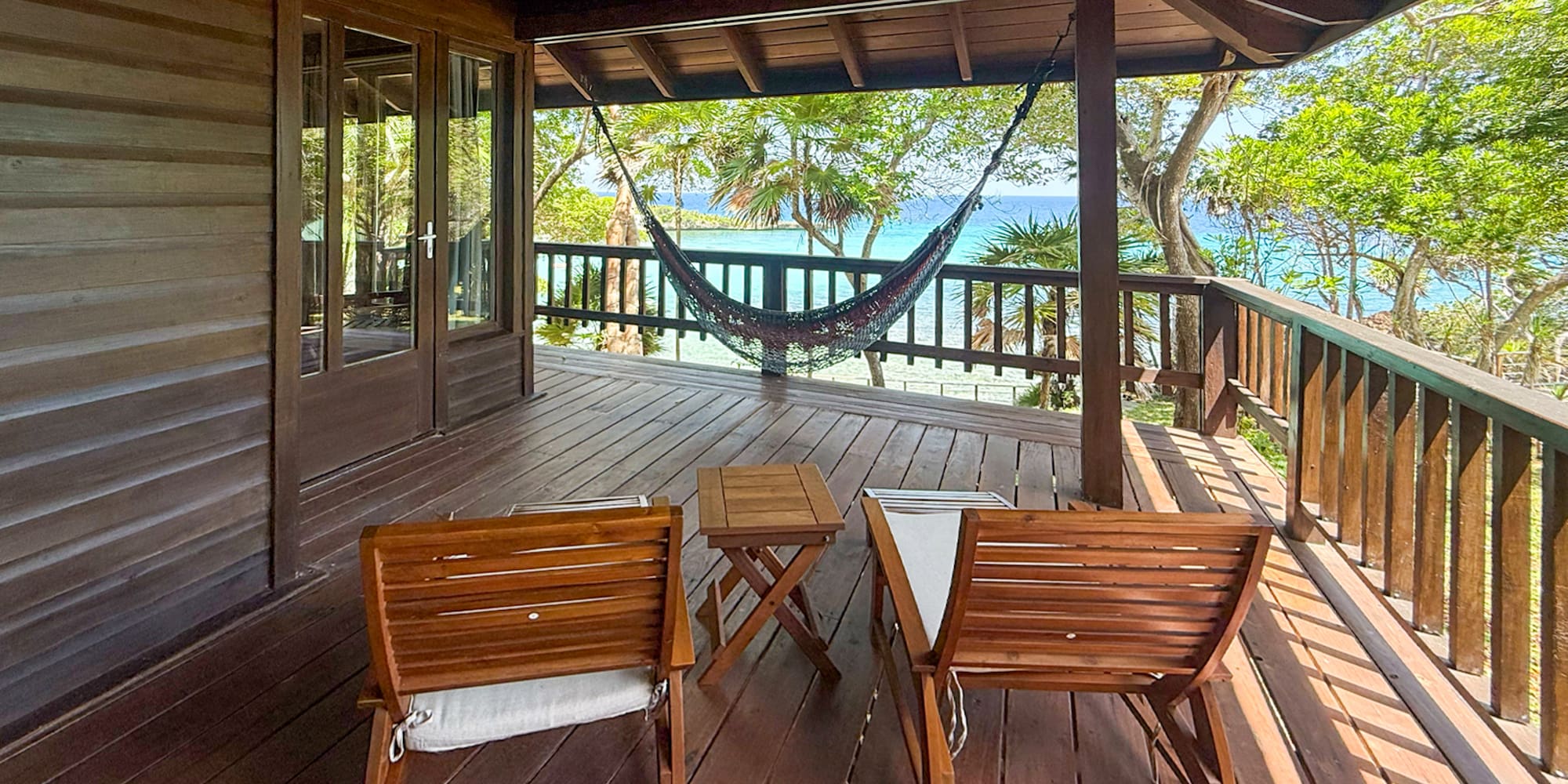 a deck with chairs and a hammock