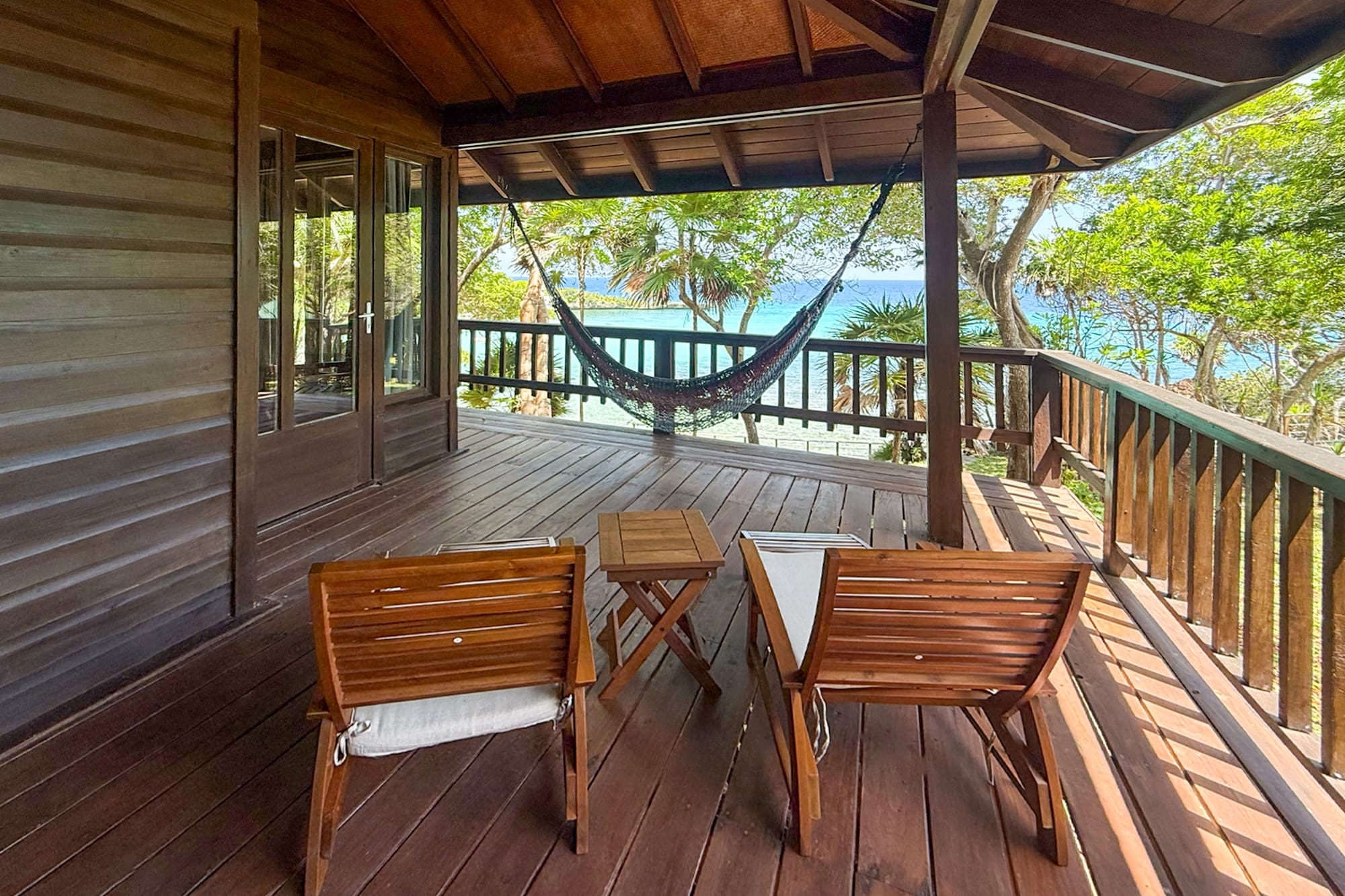 a deck with chairs and a hammock