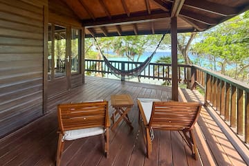 a deck with chairs and a hammock