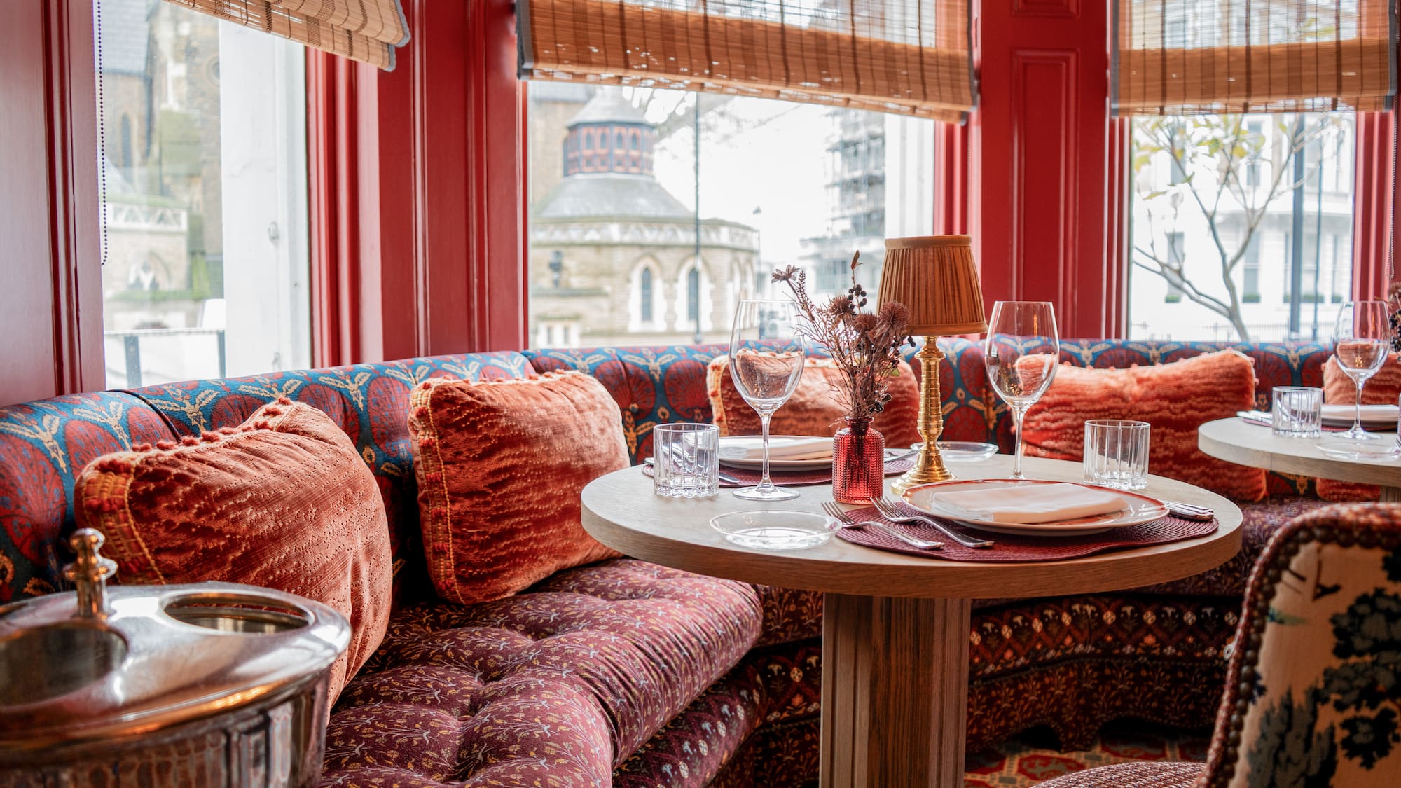 a table with wine glasses and a lamp on it