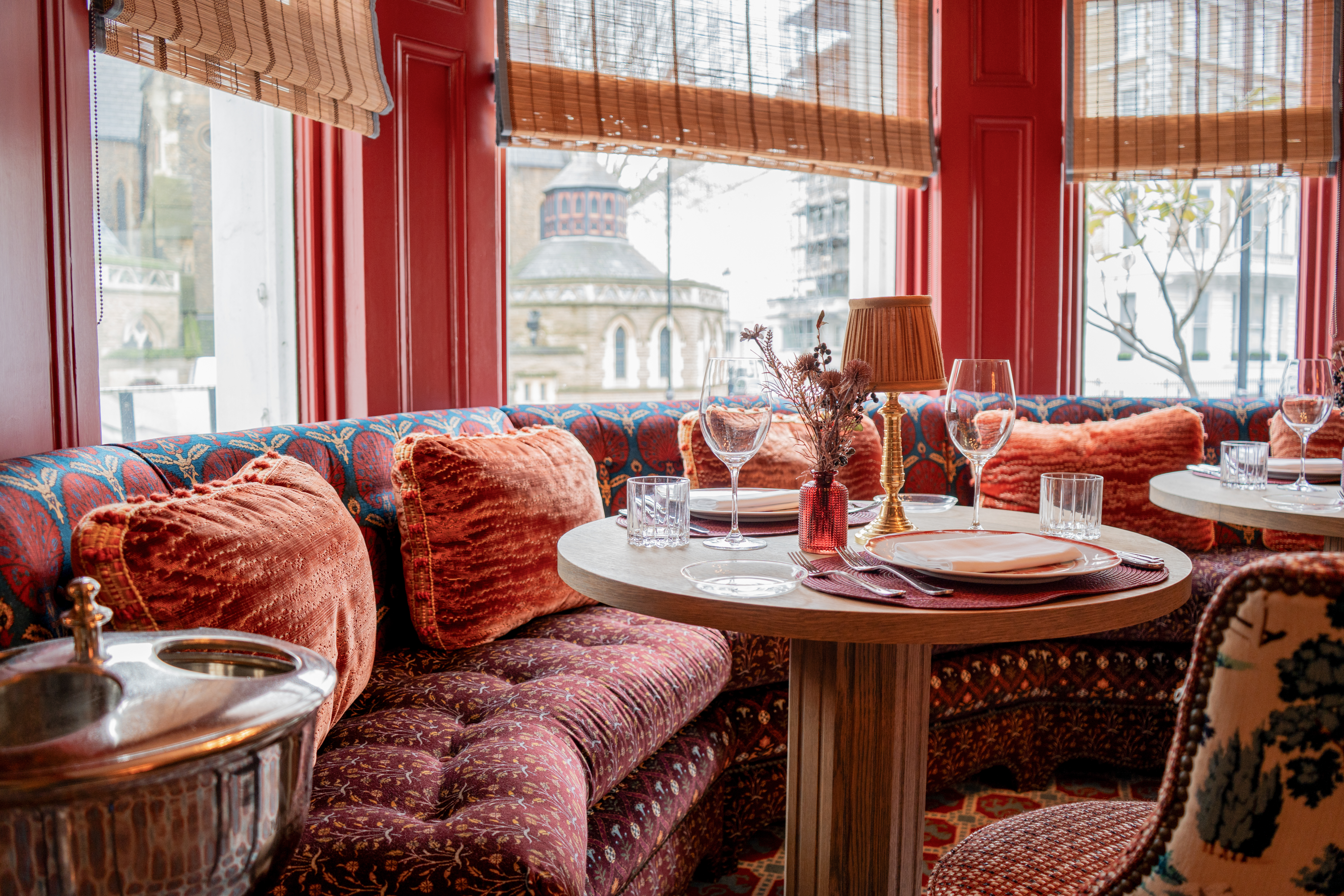 a table with wine glasses and a lamp on it