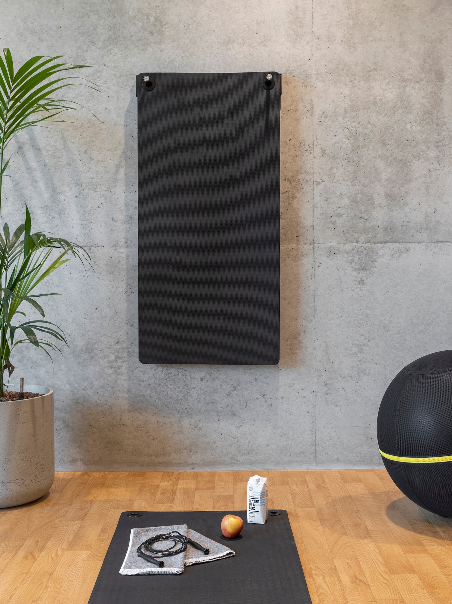 a yoga mat and exercise balls on a wooden floor