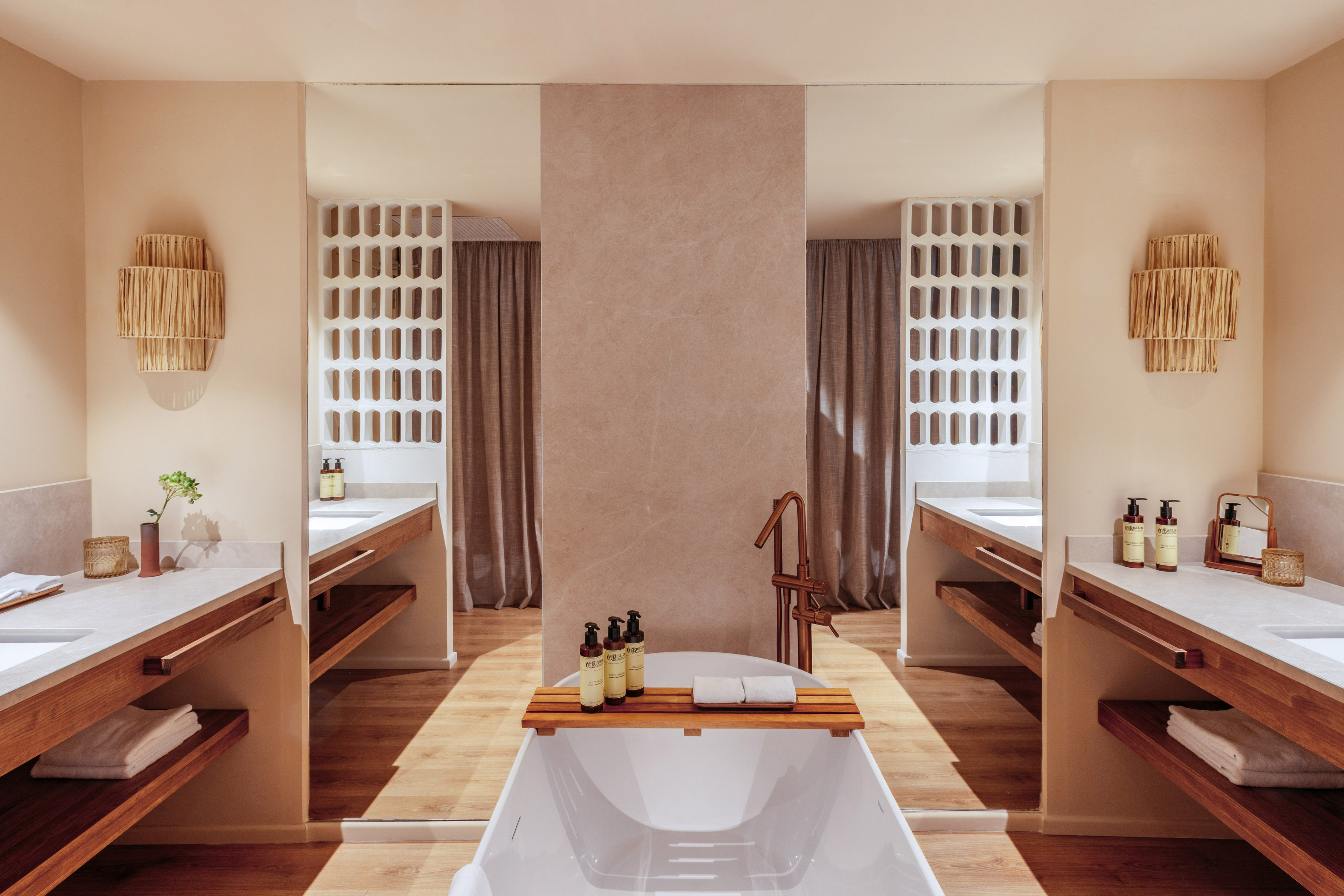 Modern bathroom with freestanding tub, double vanity, and natural wood accents.
