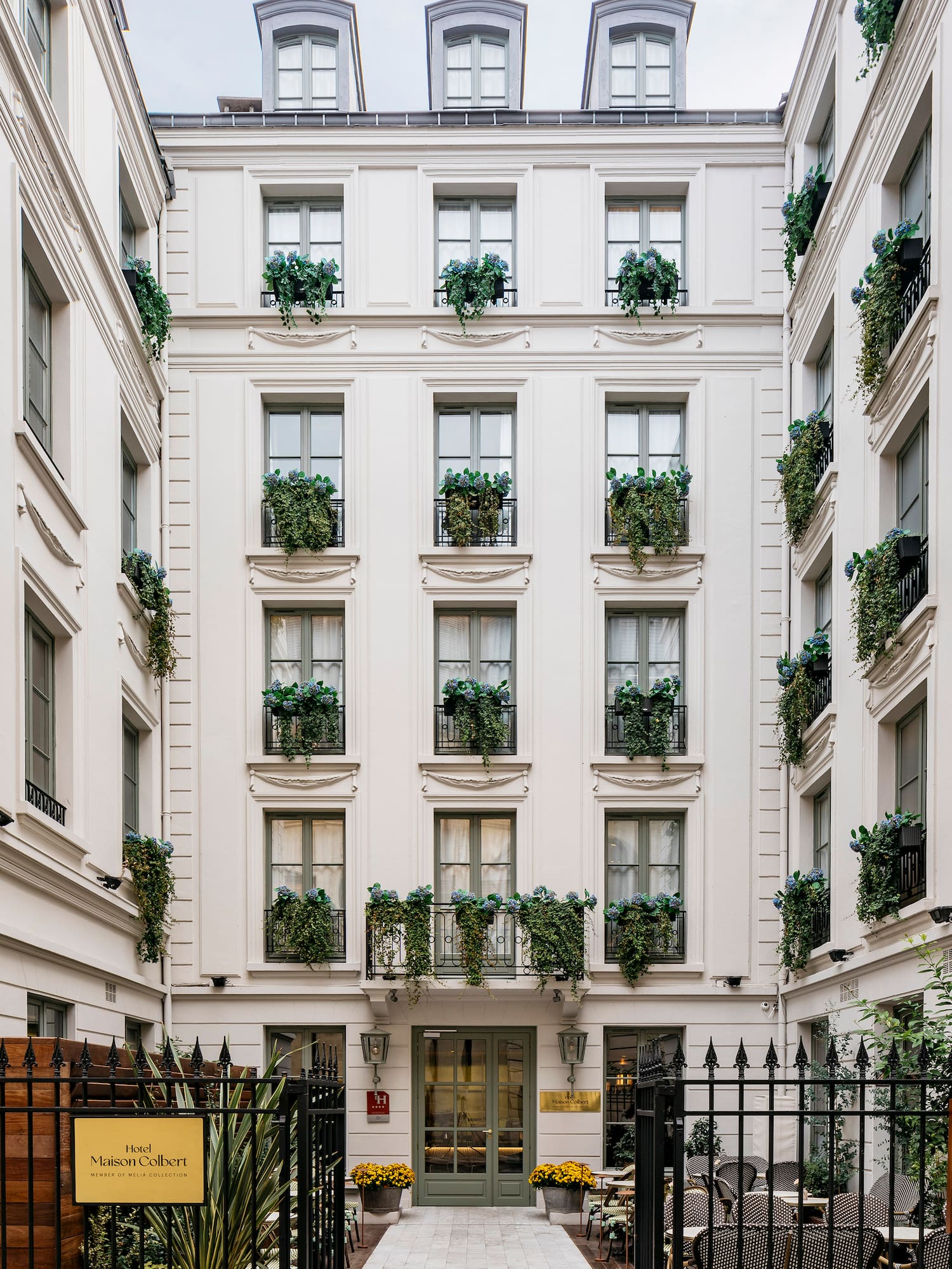 a building with many windows and plants on the outside