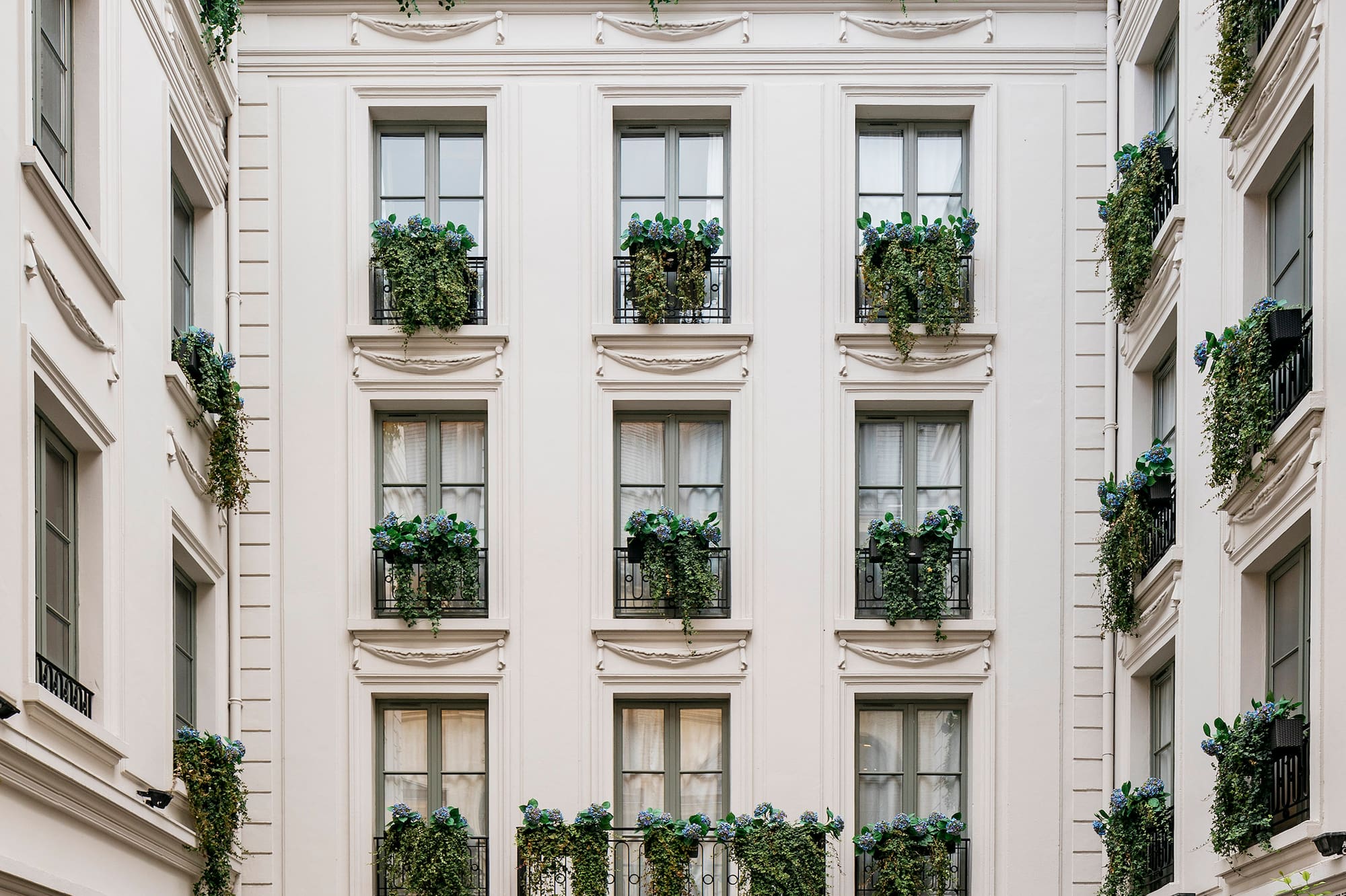 a building with many windows and plants on the outside