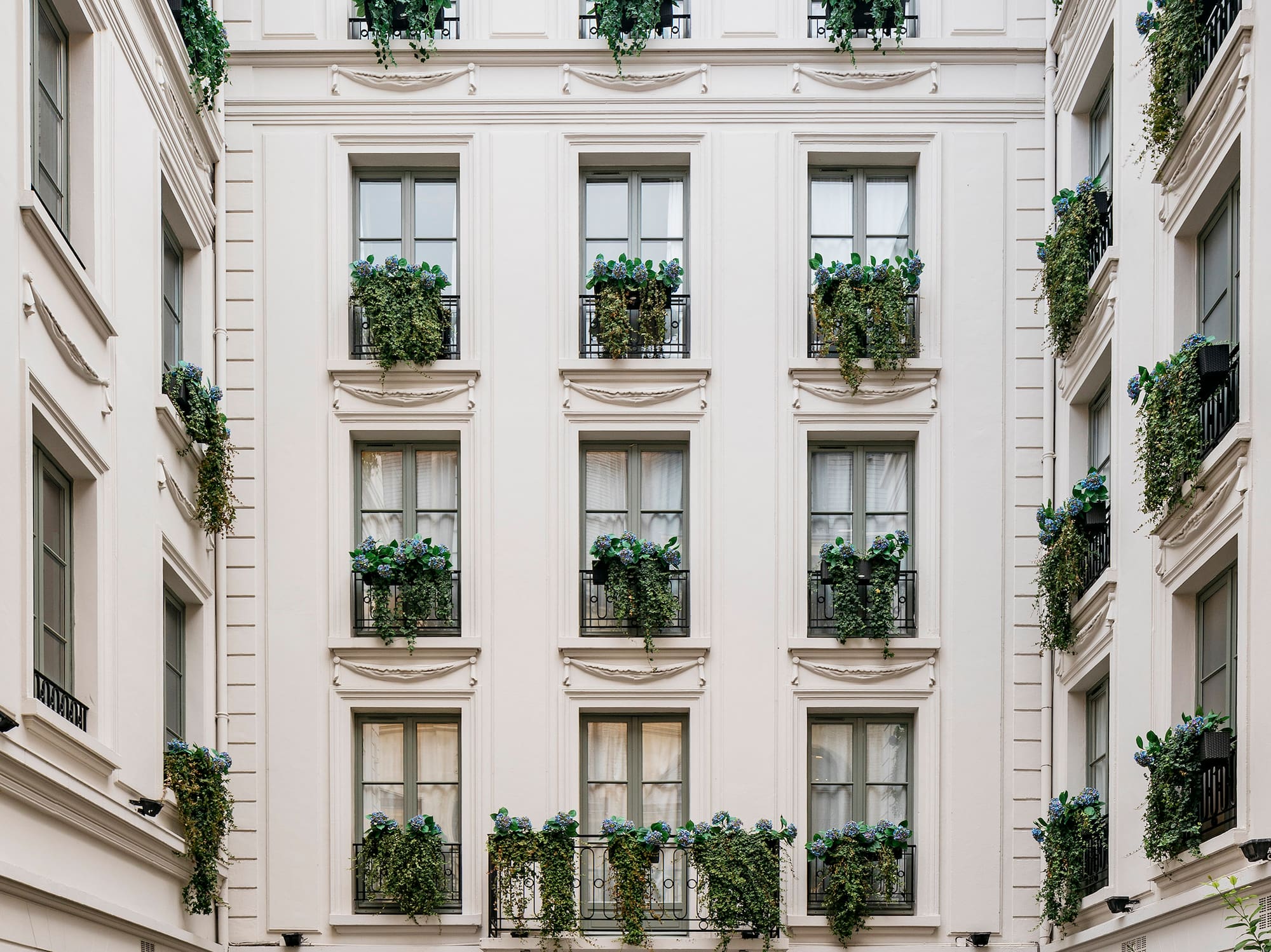 a building with many windows and plants on the outside