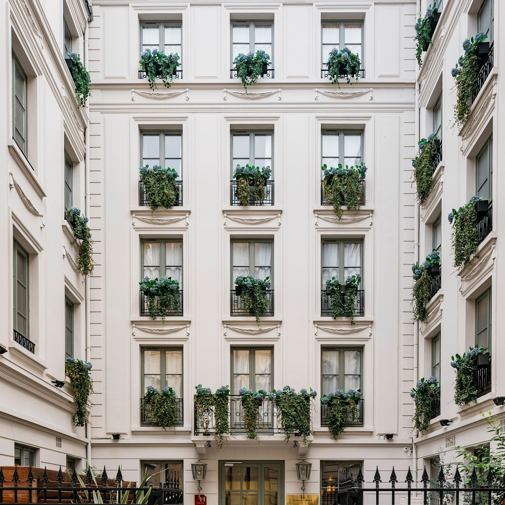 a building with many windows and plants on the outside