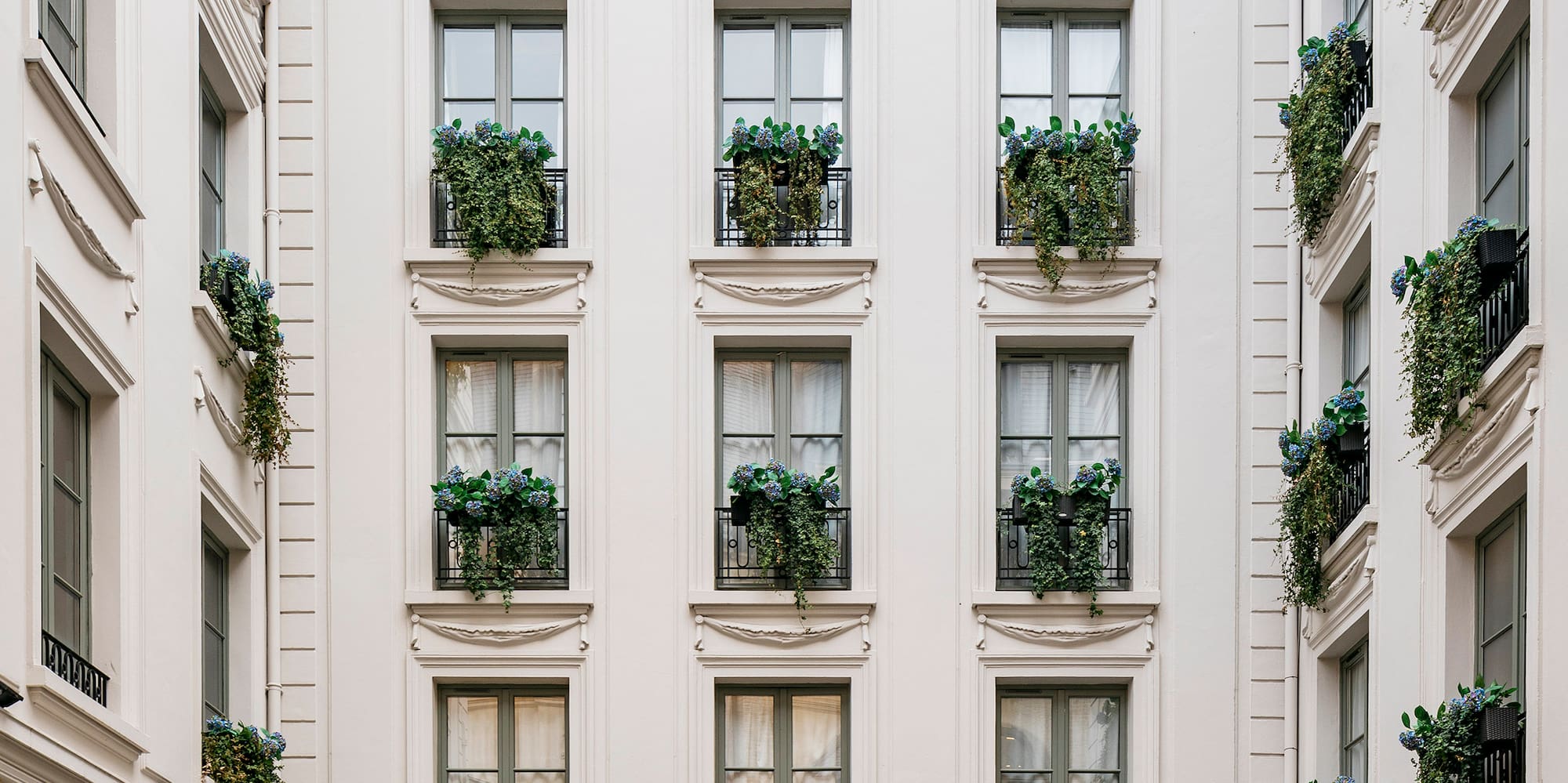 a building with many windows and plants on the outside