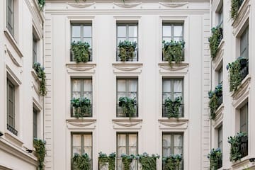 a building with many windows and plants on the outside