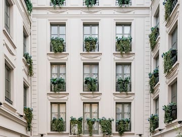 a building with many windows and plants on the outside