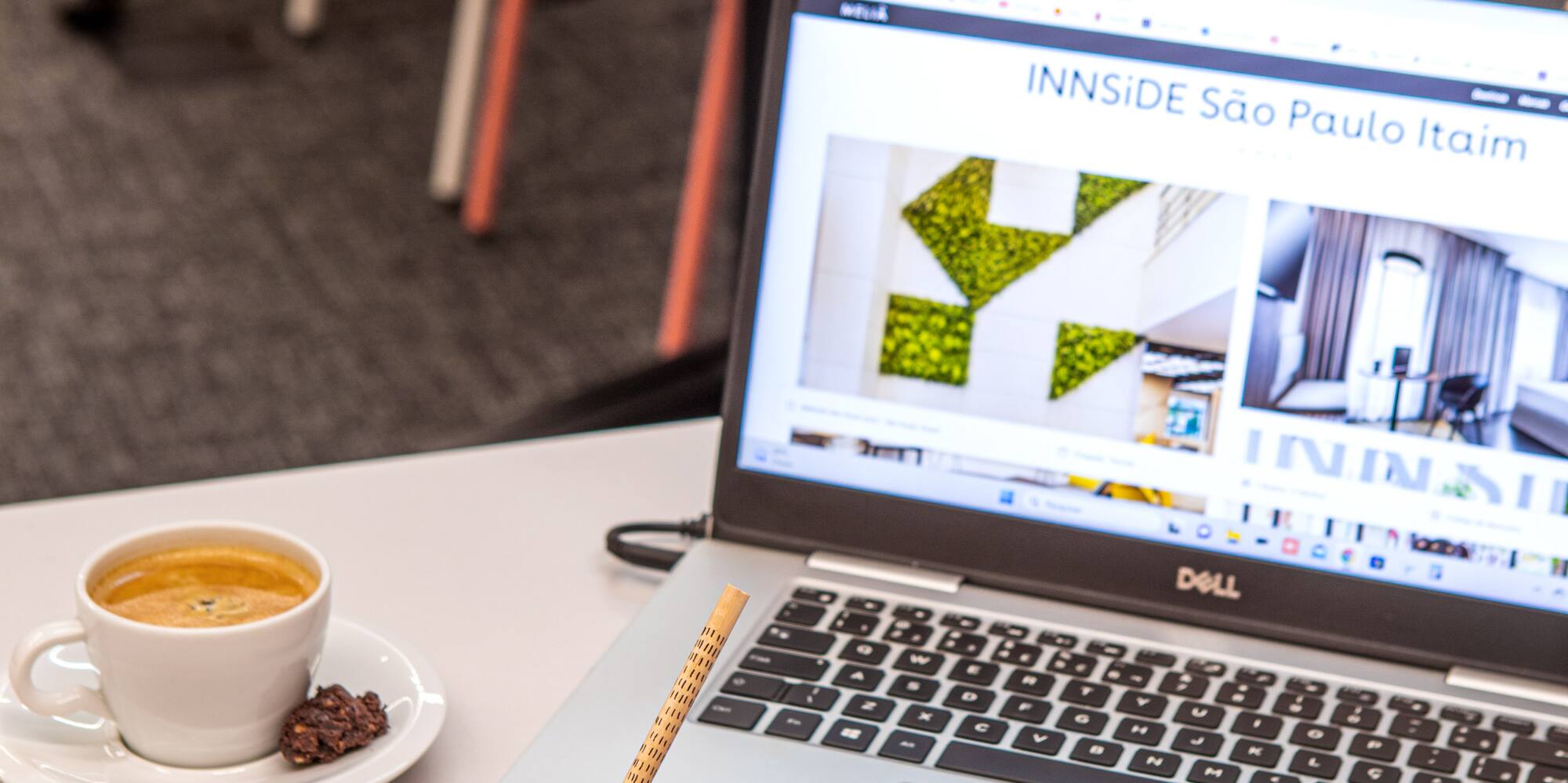 a person holding a pencil in front of a laptop