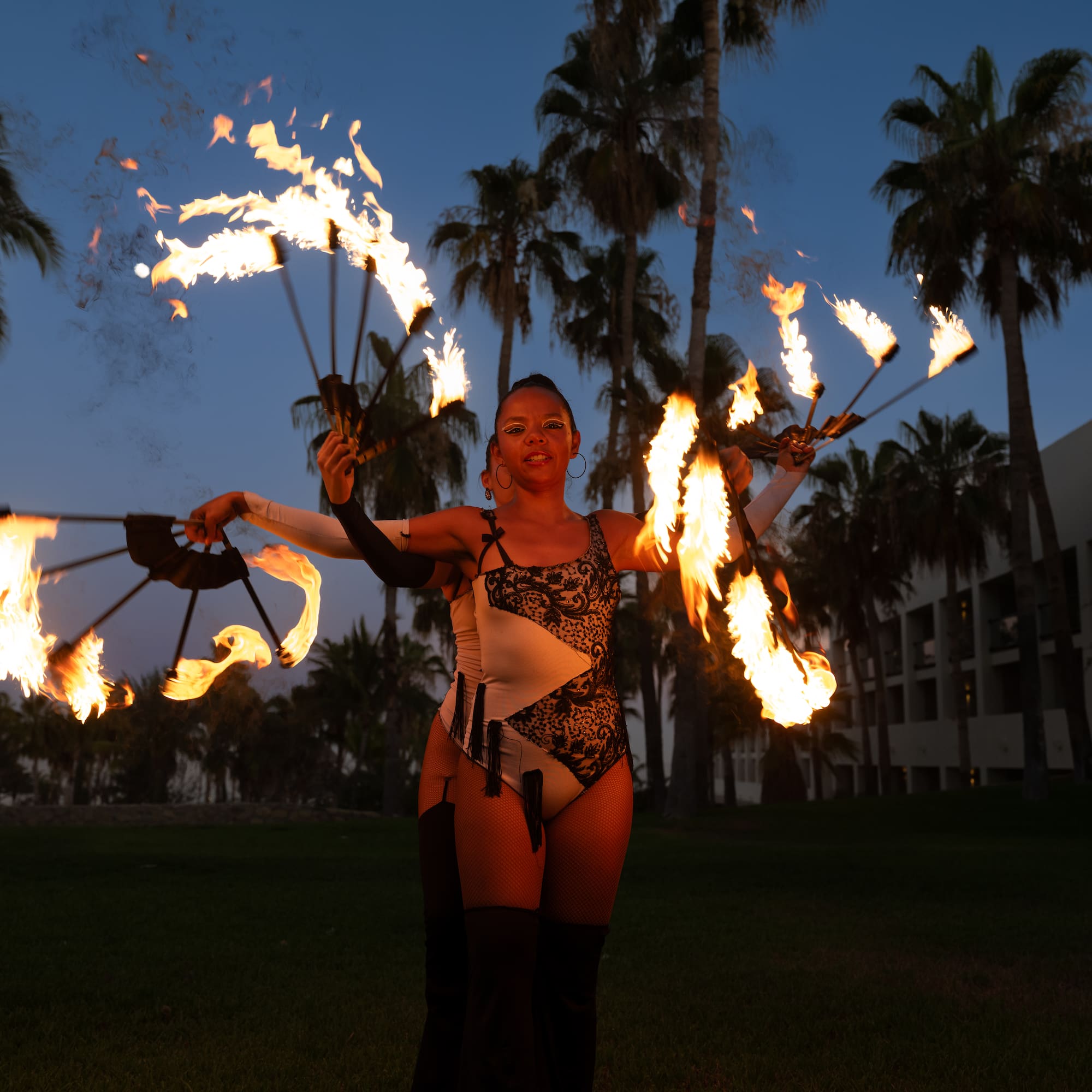 a woman with fire juggling with palm trees