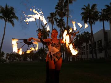 a woman with fire juggling with palm trees