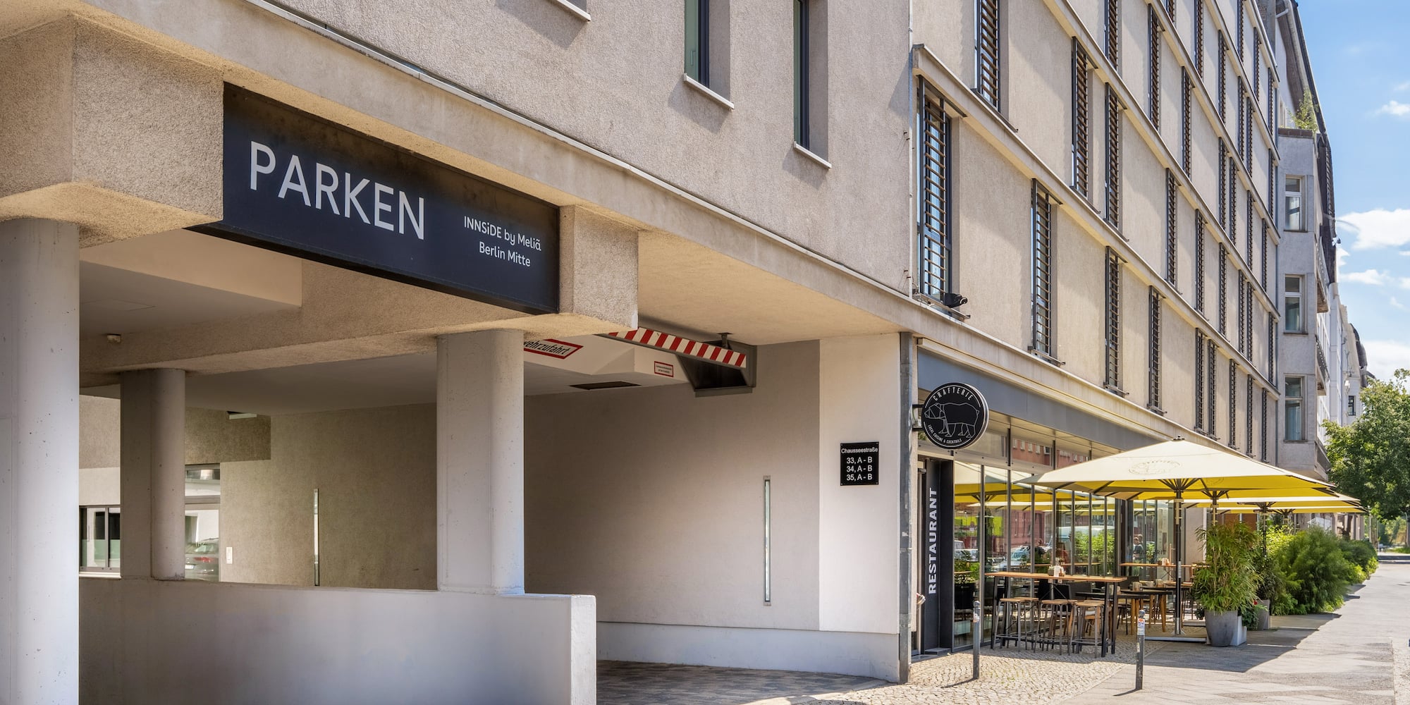 a building with a sign and a yellow umbrella