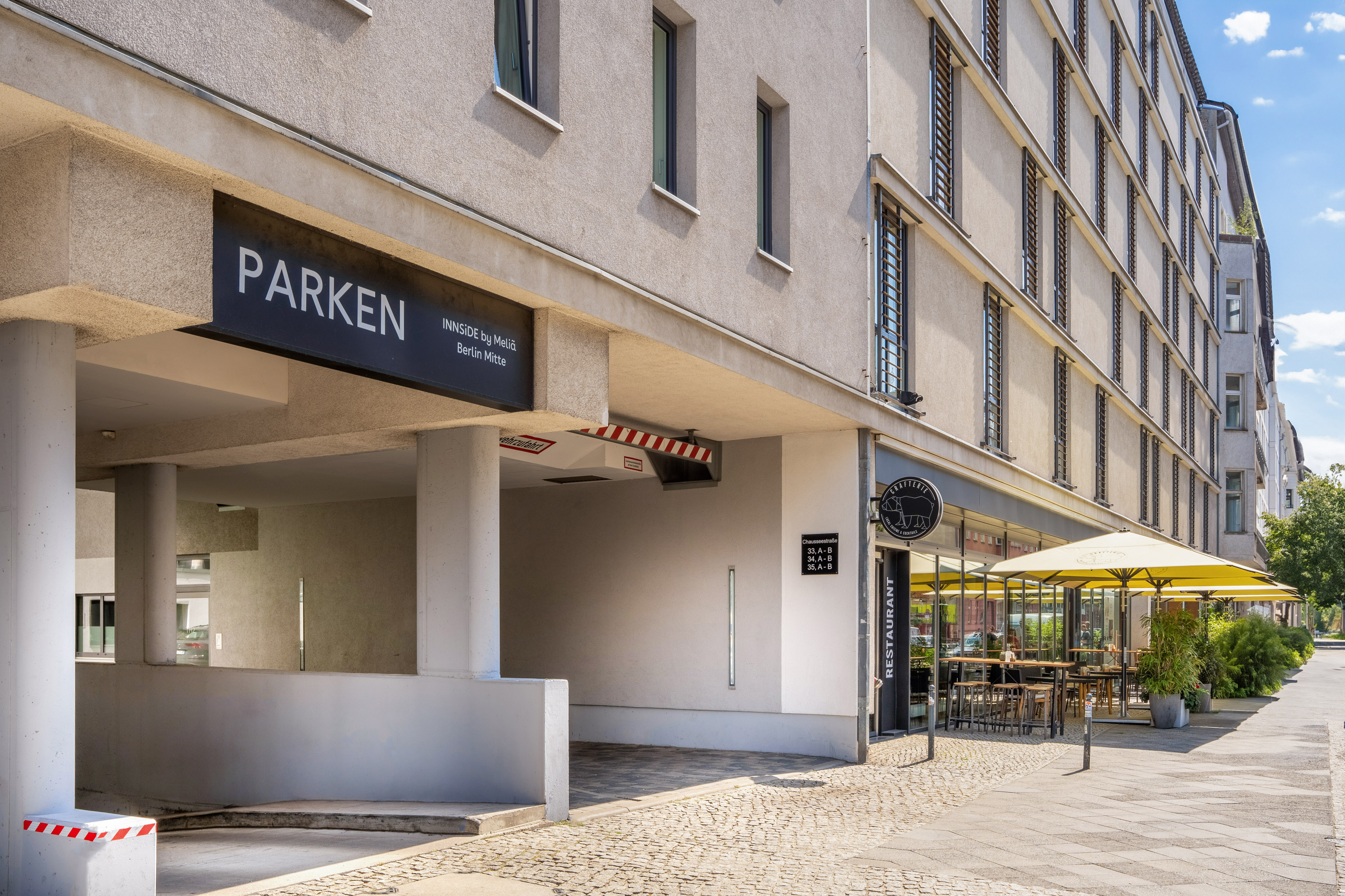 a building with a sign and a yellow umbrella