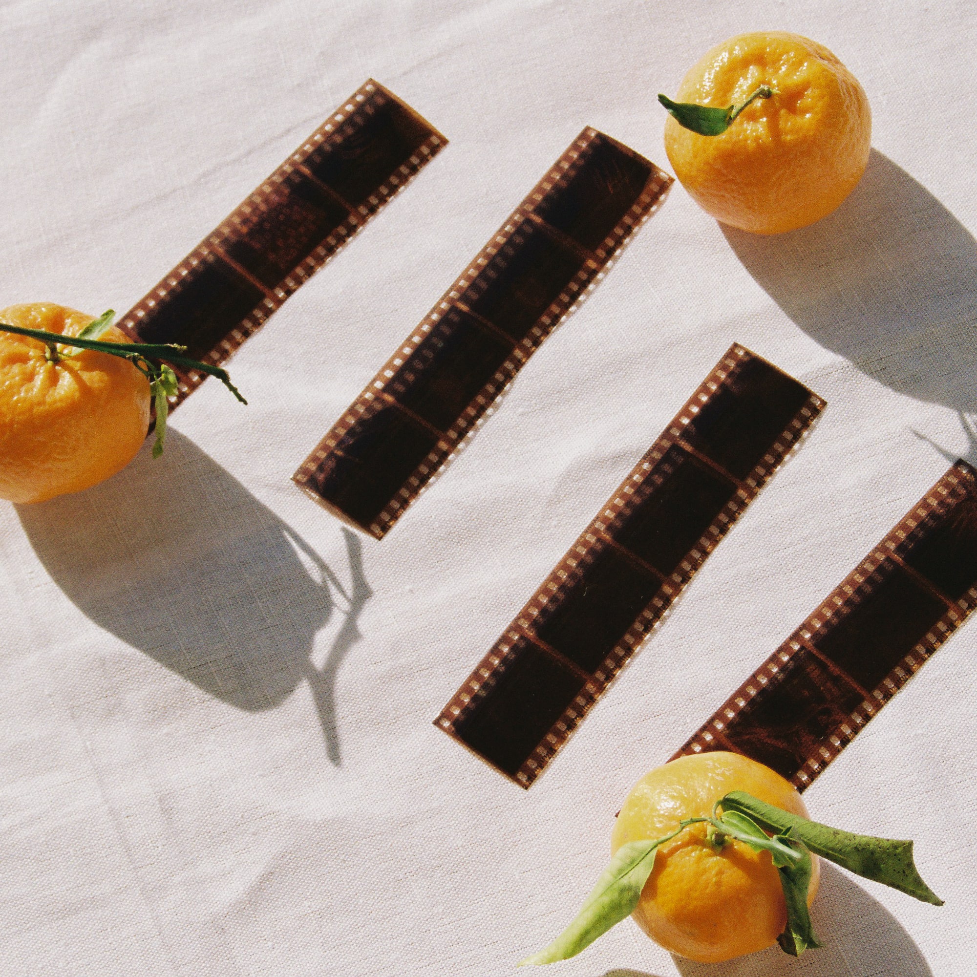 oranges and film strips on a white surface