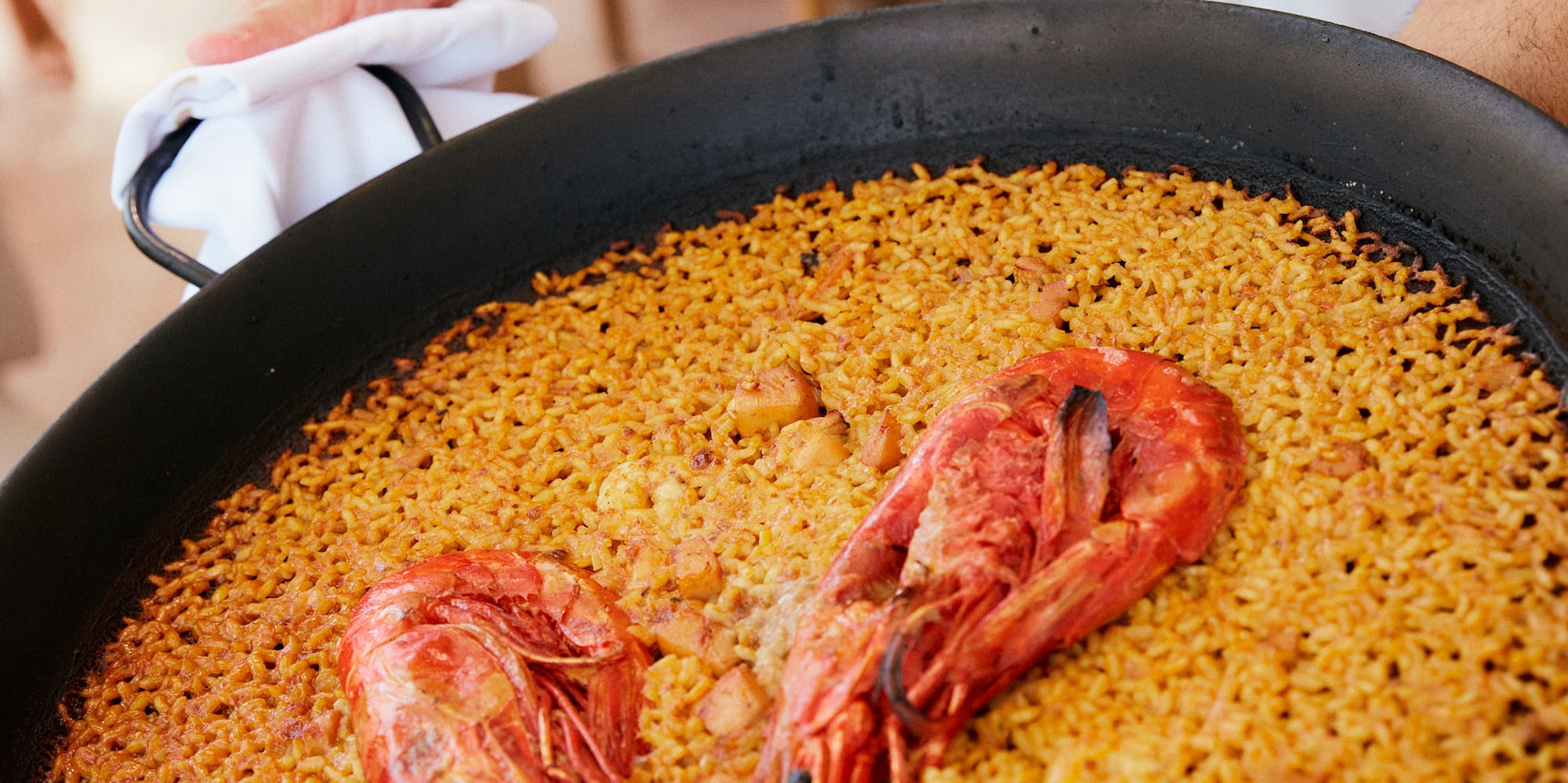 a person holding a pan of food