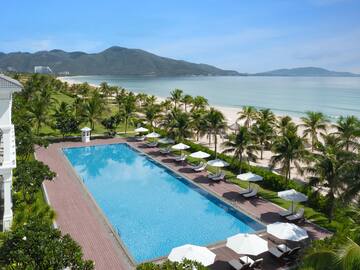 a swimming pool with palm trees and a beach.