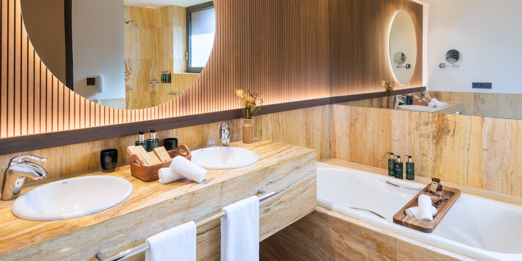 a bathroom with a large round mirror and a tub