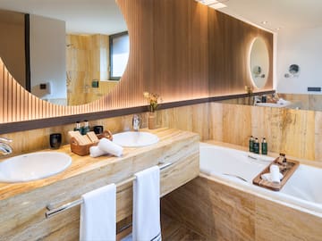 a bathroom with a large round mirror and a tub