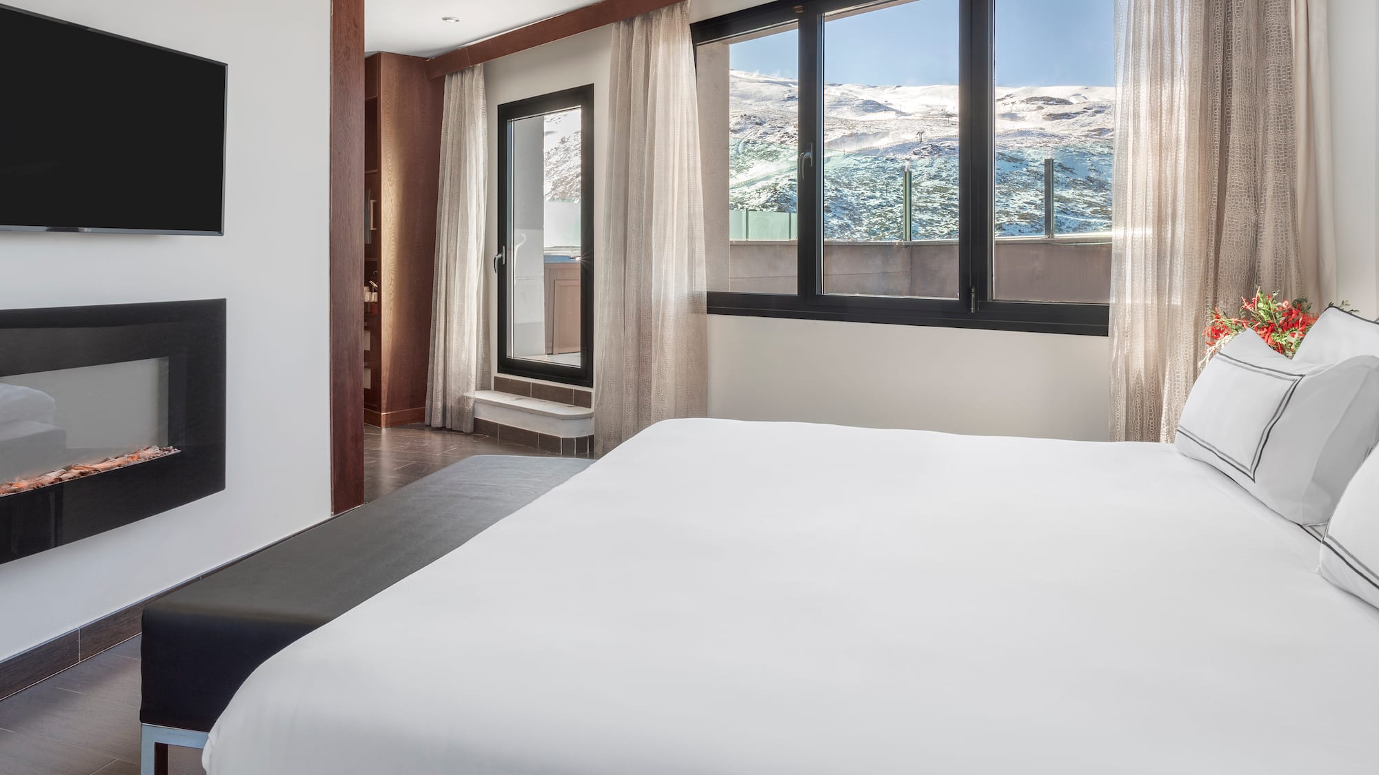 a bed in a room with a window and a view of the mountains