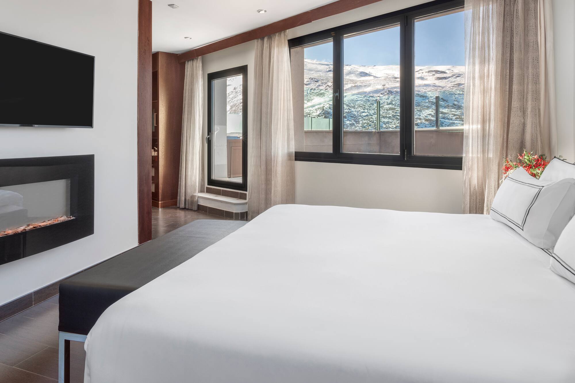 a bed in a room with a window and a view of the mountains