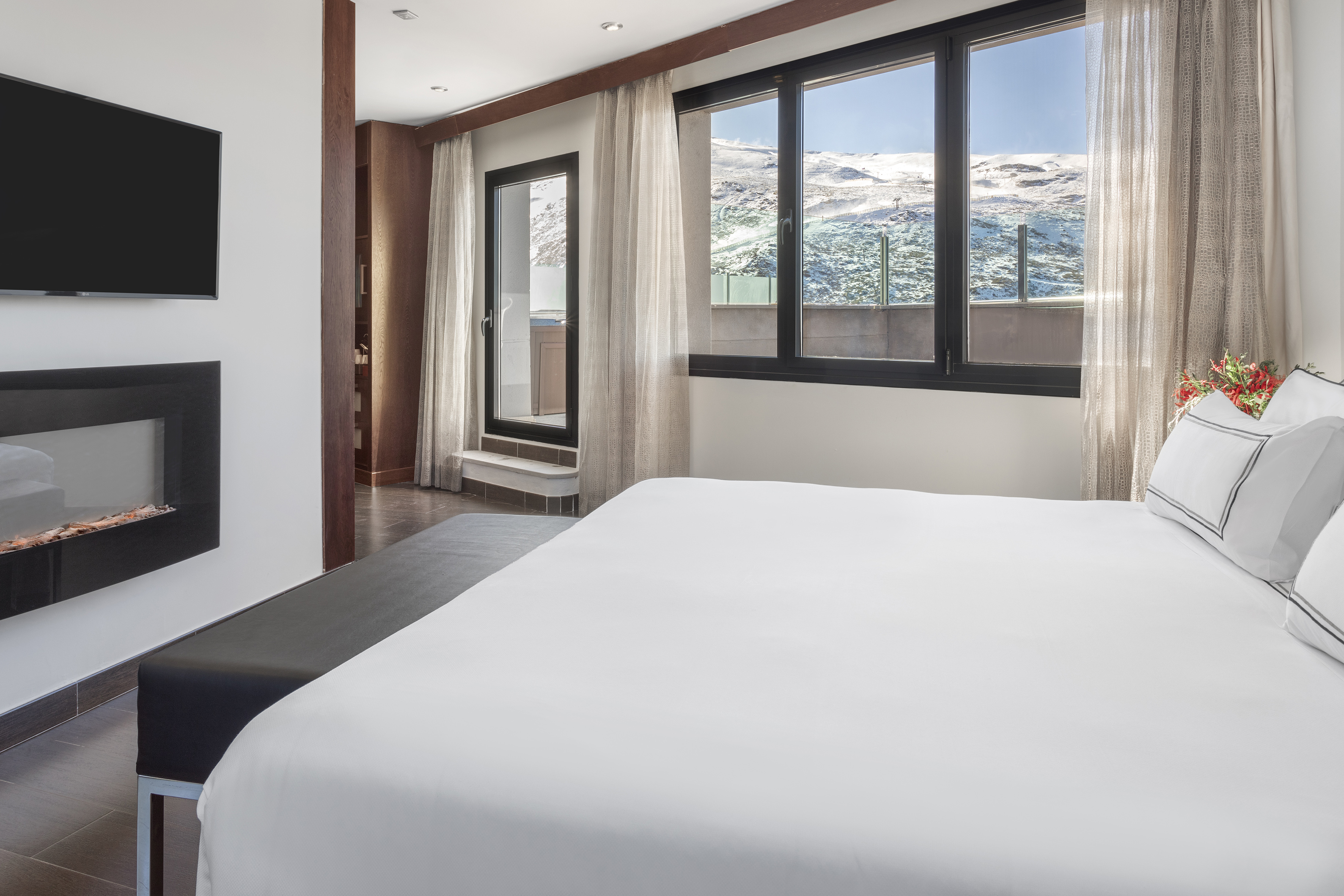 a bed in a room with a window and a view of the mountains