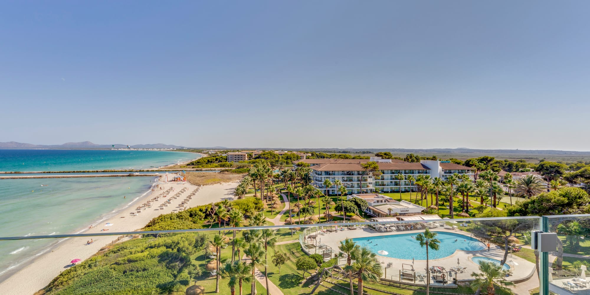 a pool and beach with palm trees