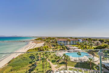 a pool and beach with palm trees