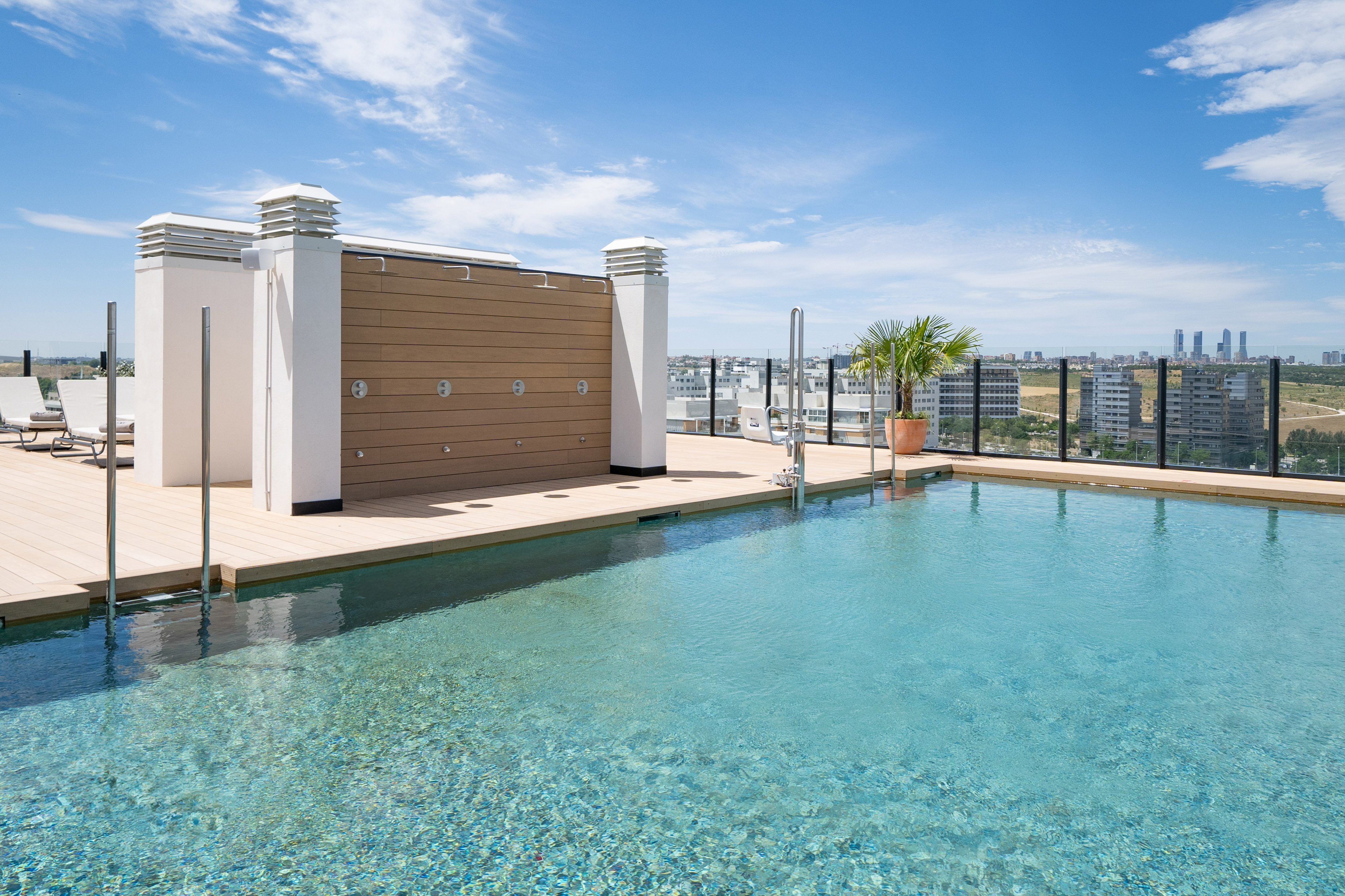 a swimming pool with a rooftop and a city in the background