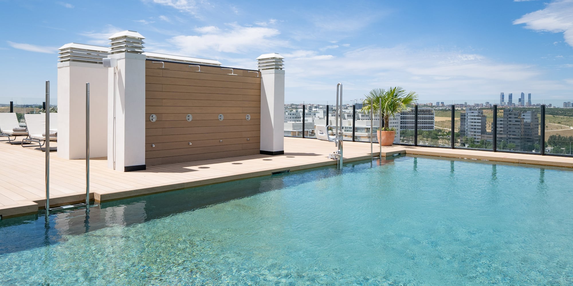 a swimming pool with a rooftop and a city in the background