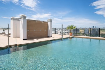 a swimming pool with a rooftop and a city in the background