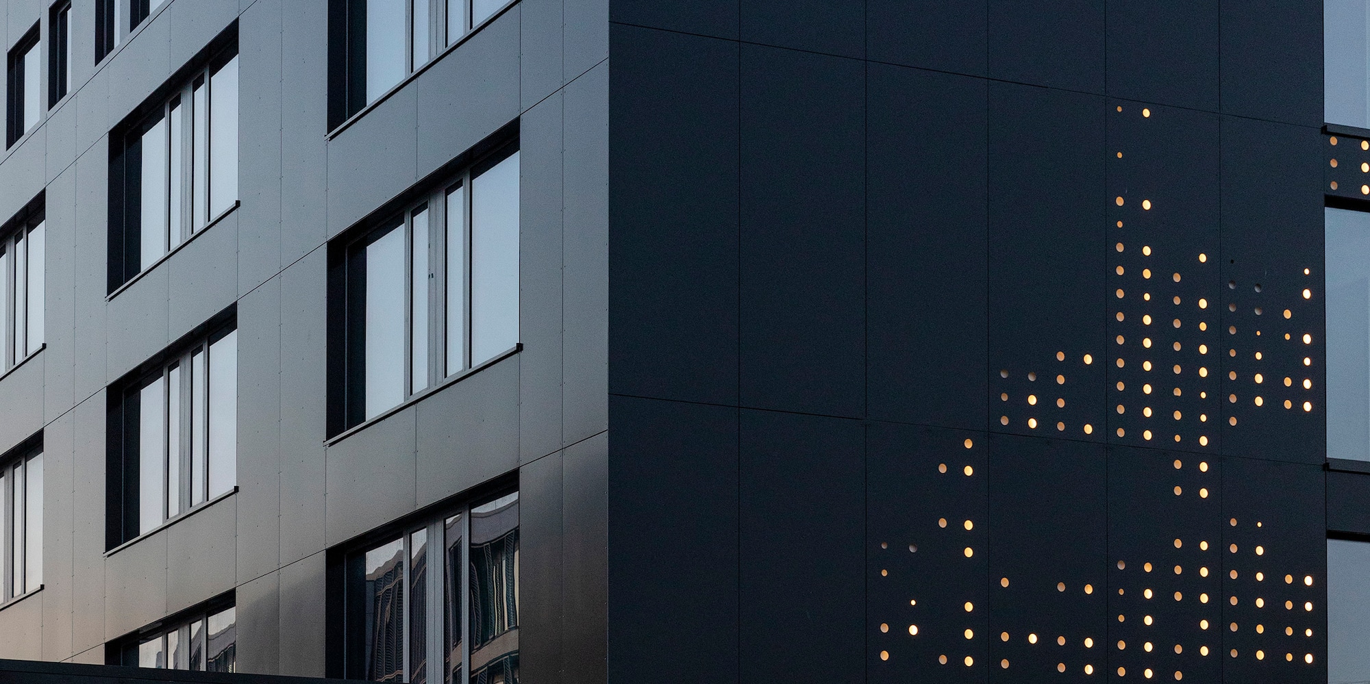 INNSiDE hotel, modern black building with illuminated dot pattern facade.
