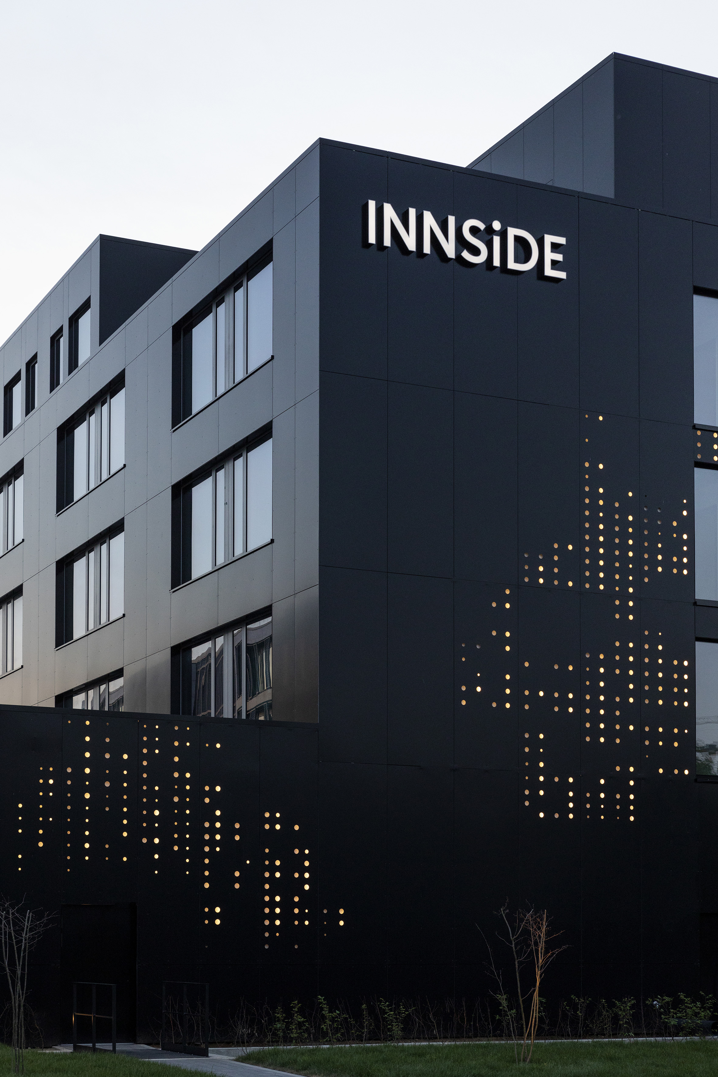 INNSiDE hotel, modern black building with illuminated dot pattern facade.